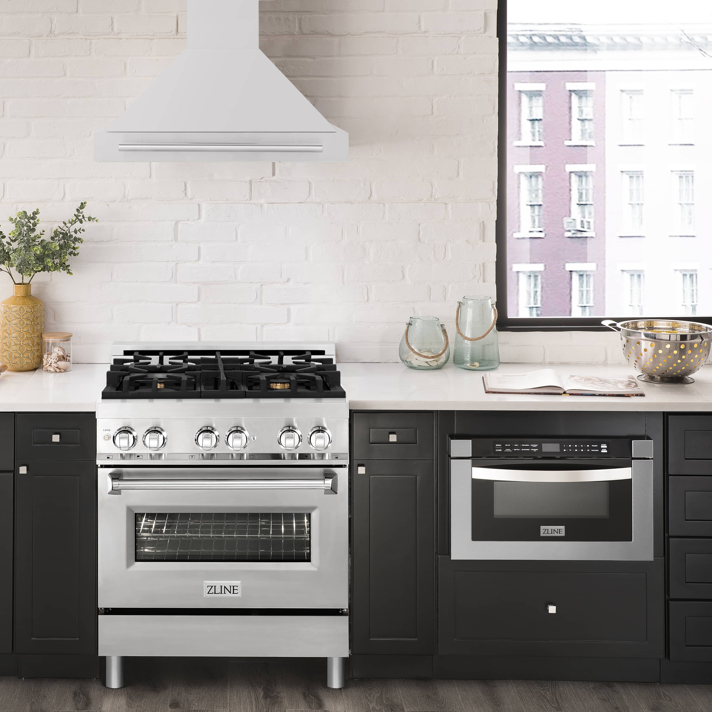 Wall-mounted stainless steel range hood above a black cooktop in a modern kitchen