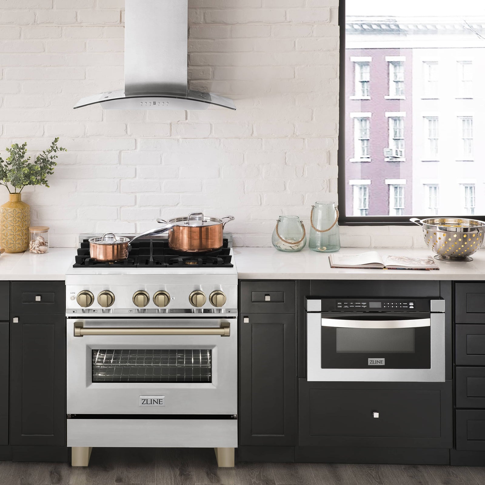 Stainless steel dual-fuel range with chimney hood and cookware on grates