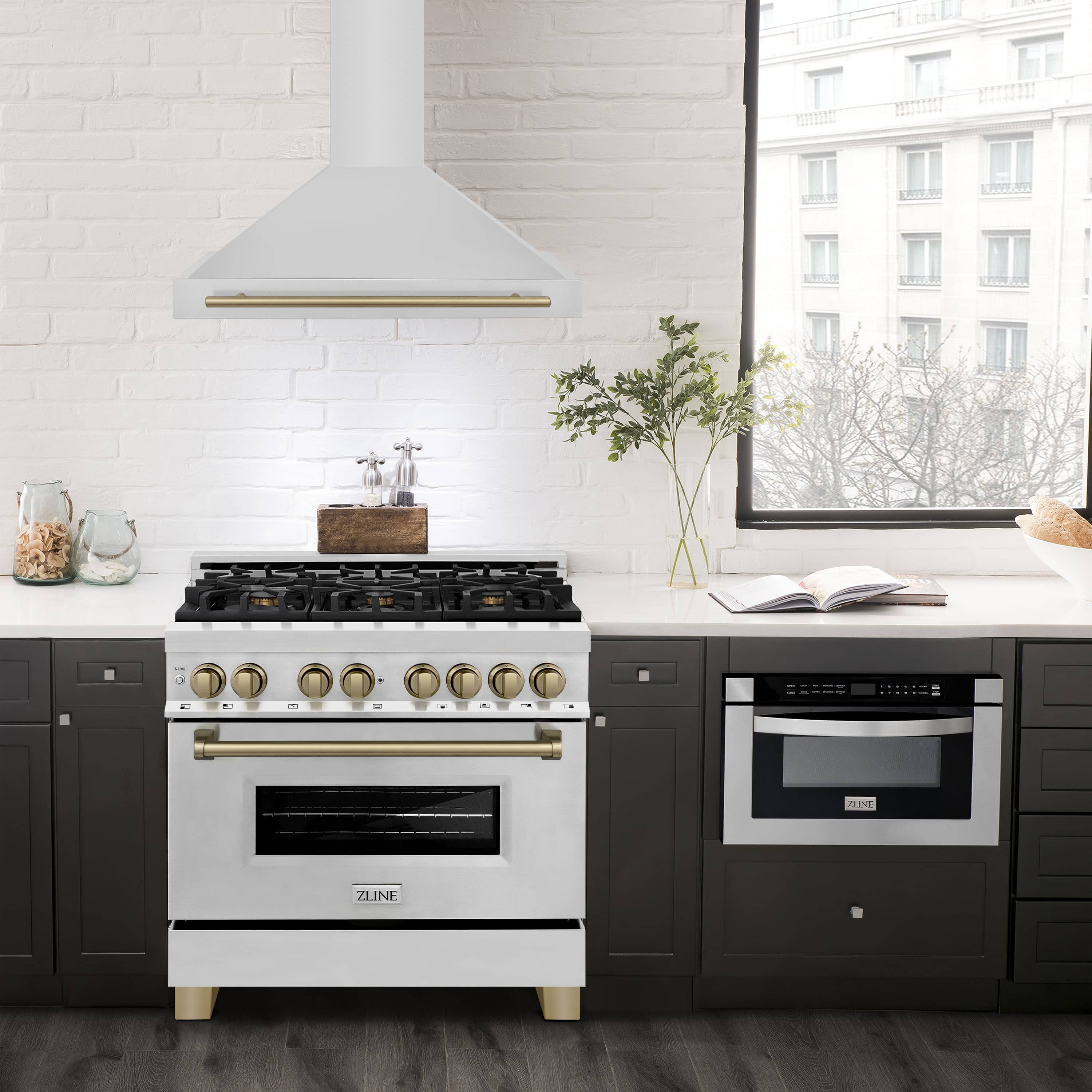 Stainless steel wall range hood above a cooktop, with champagne bronze accent trim