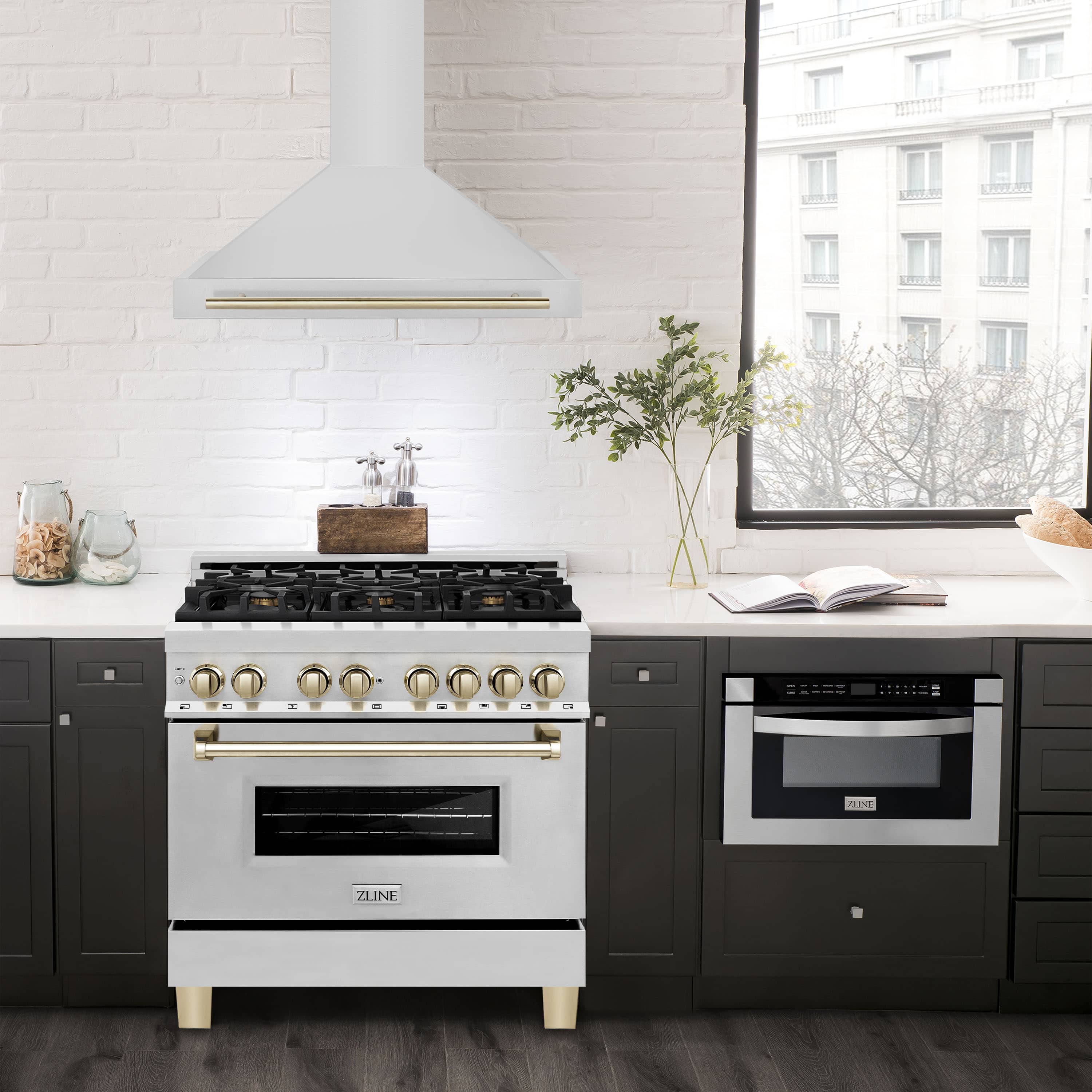 Wall-mounted chimney range hood above a cooktop, white stainless with gold edge trim