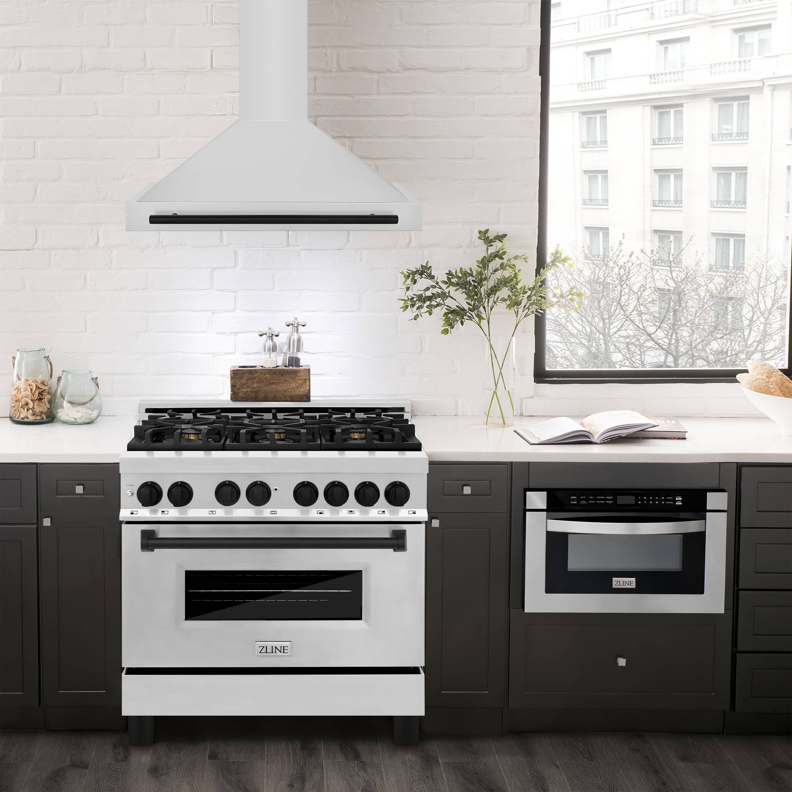 Stainless chimney range hood with matte black trim over a cooktop, wall-mounted