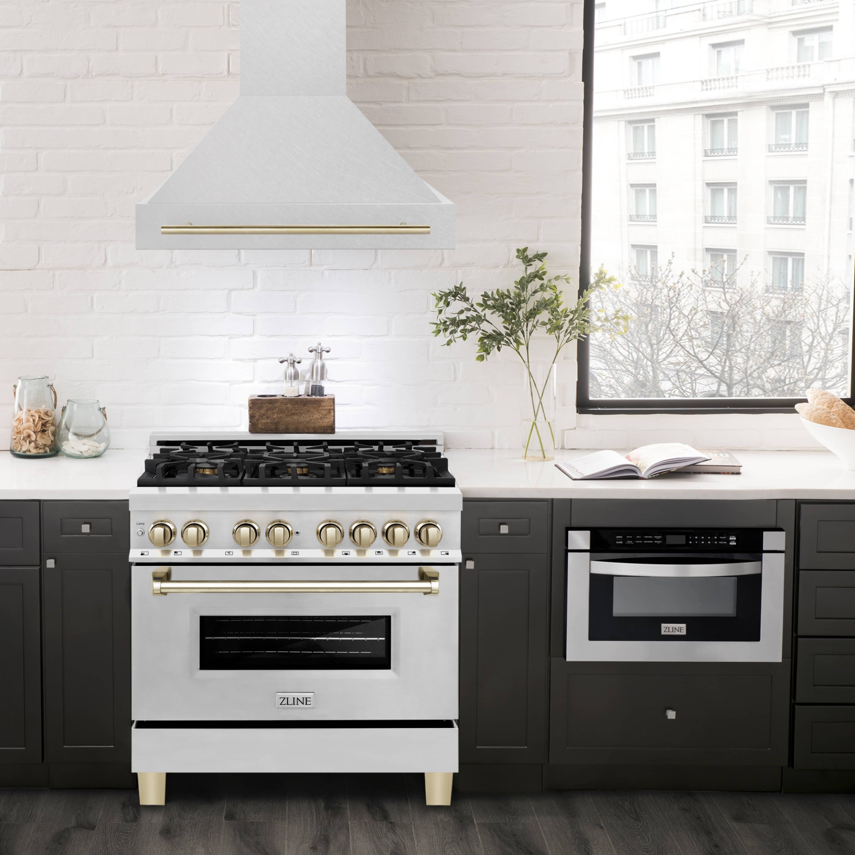 Wall-mounted range hood over cooktop, satin stainless steel chimney with gold handle trim