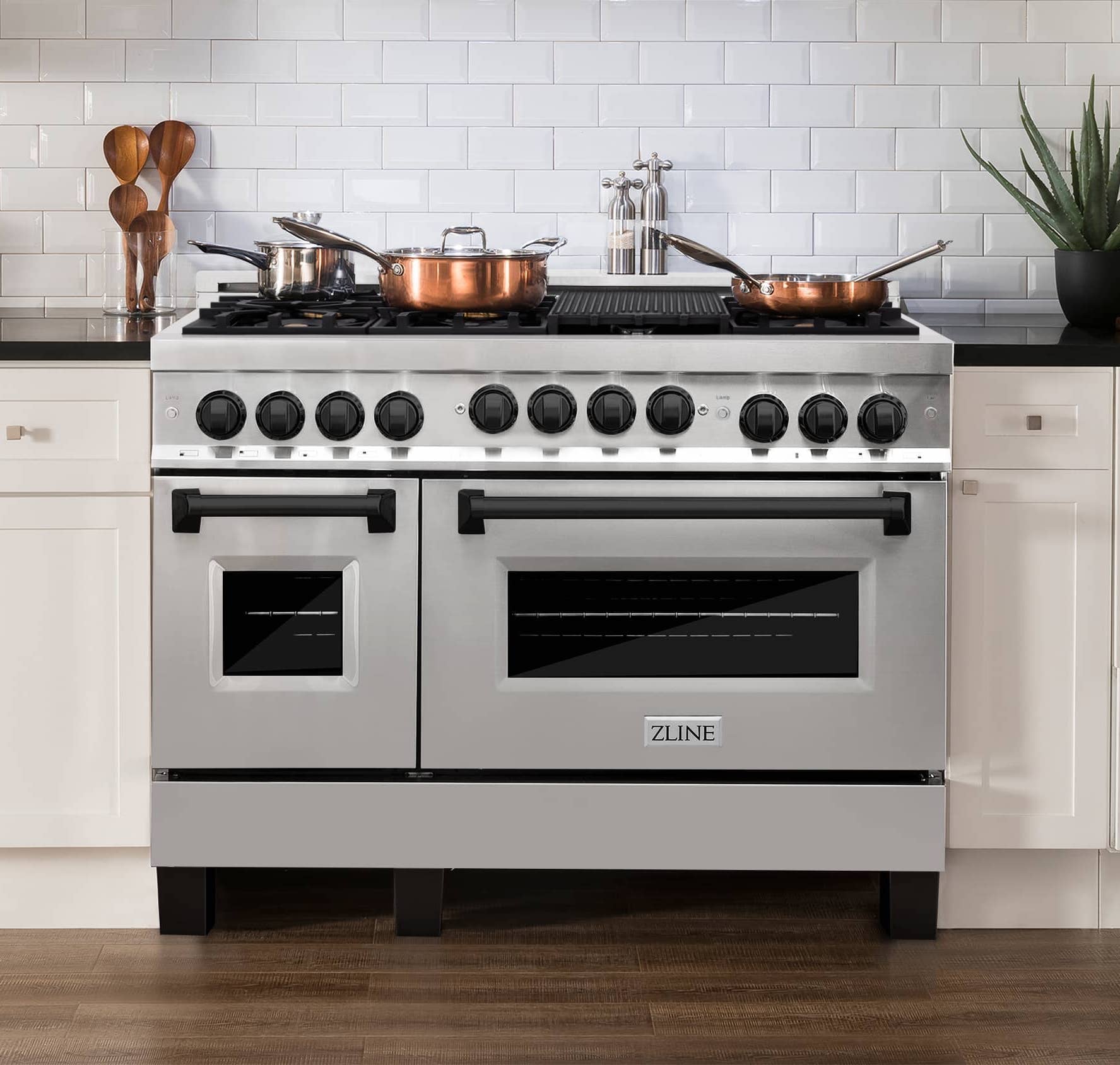 Stainless steel gas range with four burners, two ovens, and black control knobs