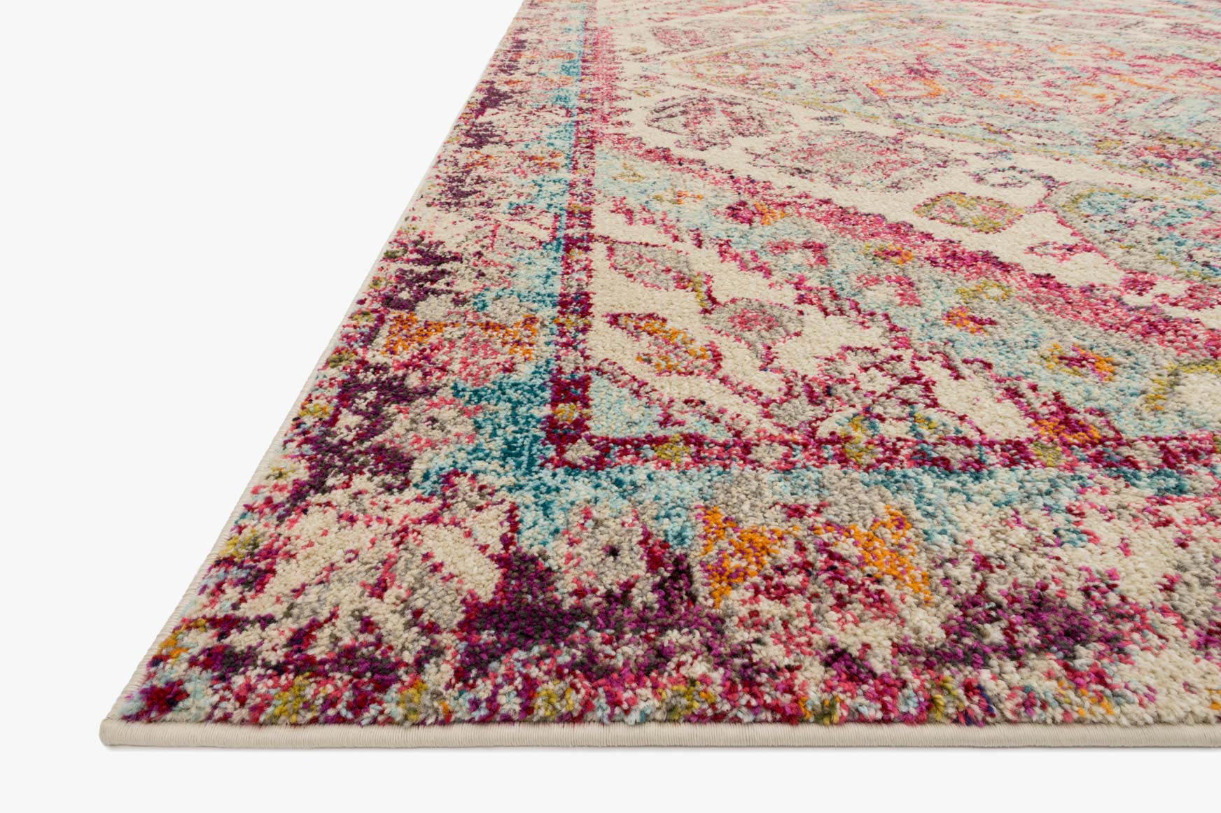 Corner view of aqua and pink ornate rug with distressed texture and border