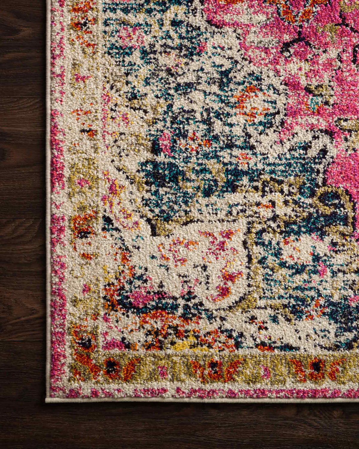 Close-up of pink rug with cream center medallion and navy accents, textured weave