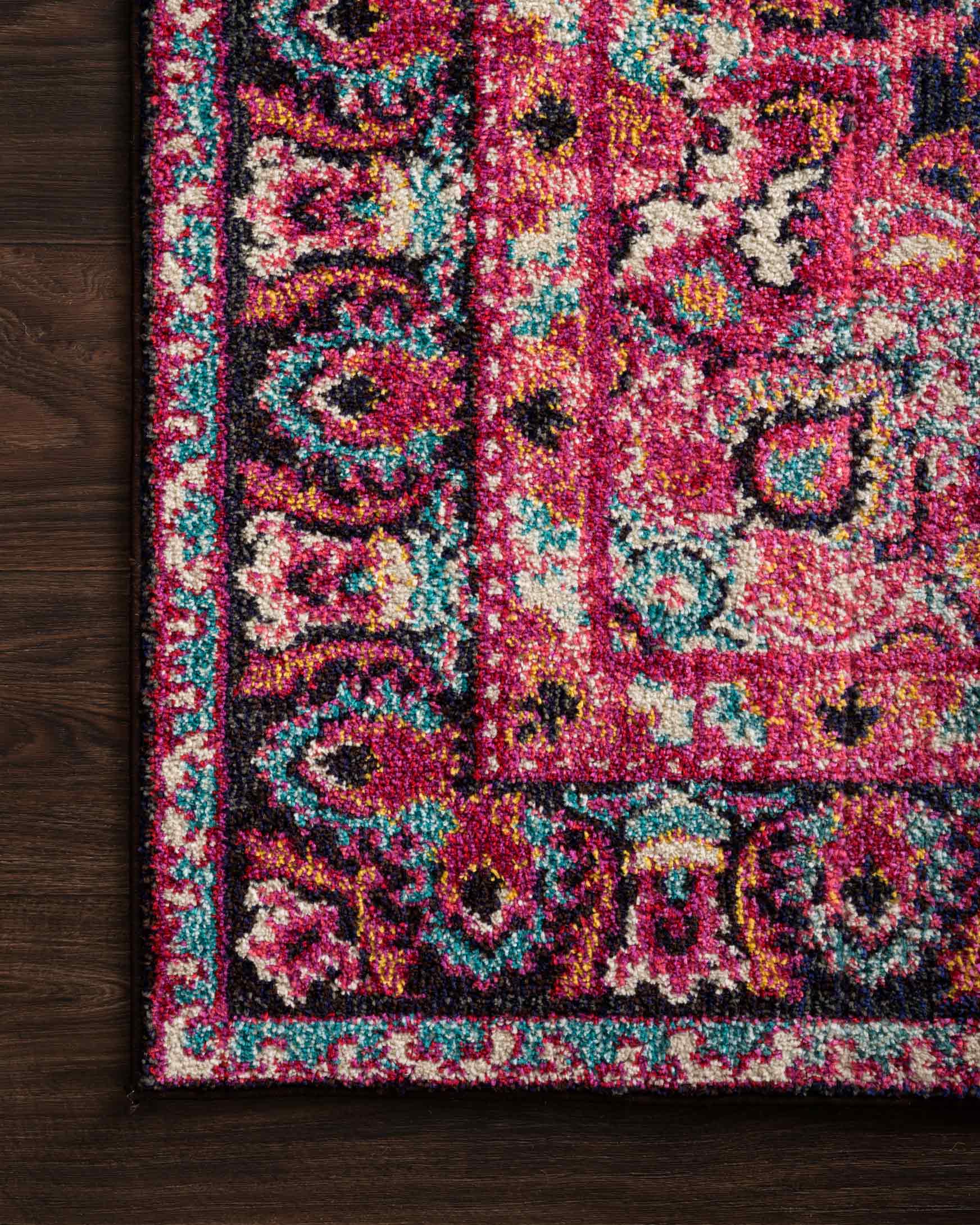 Close view of multicolor floral rug pile with navy, pink, teal and speckled detail.