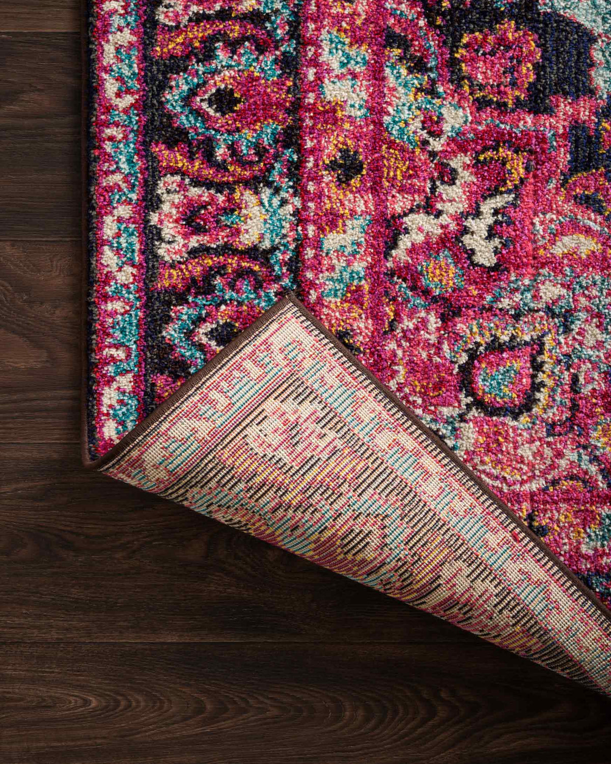 Rug edge detail in dark navy with pink, teal, and multicolor ornamental pattern