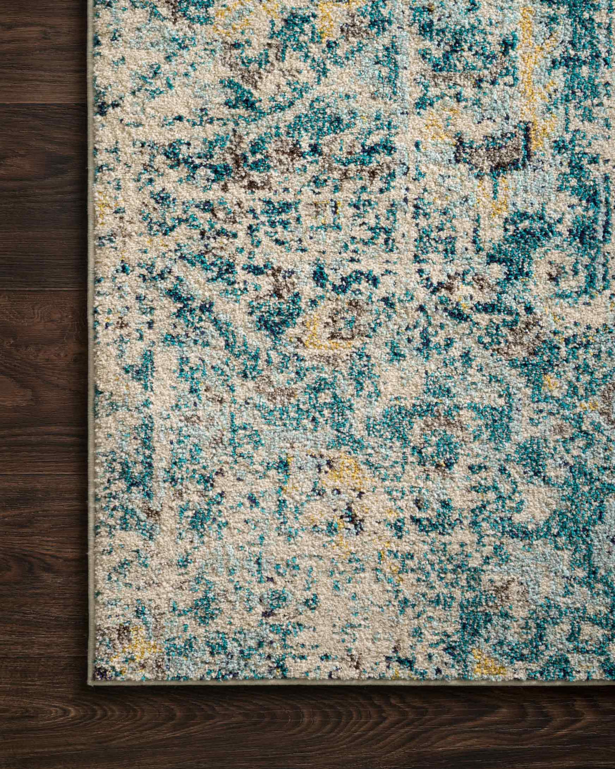 Aqua and navy abstract distressed rug with ornate panel motif, close-up