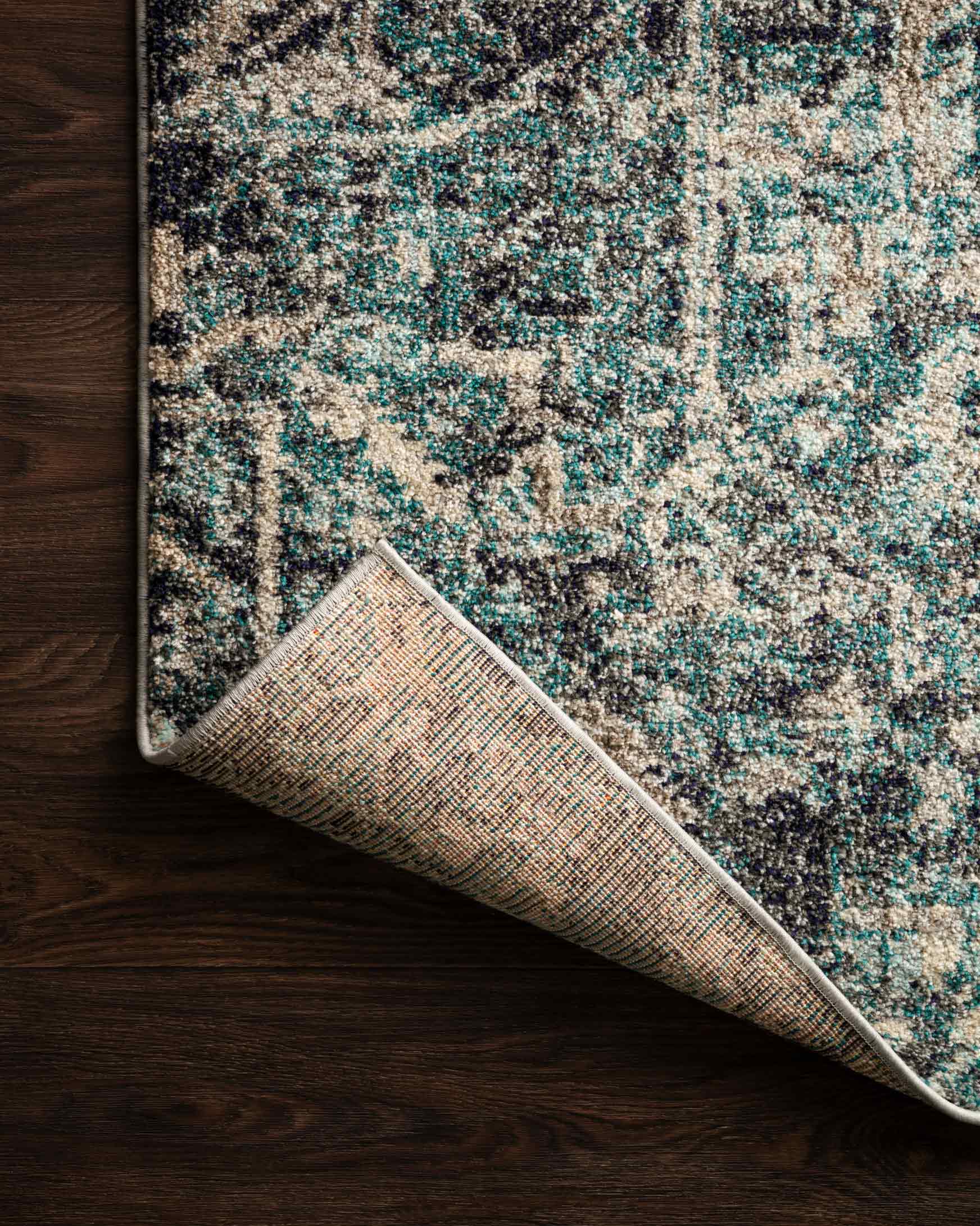 Smoke and slate power-loomed rug edge with textured weave and distressed pattern.