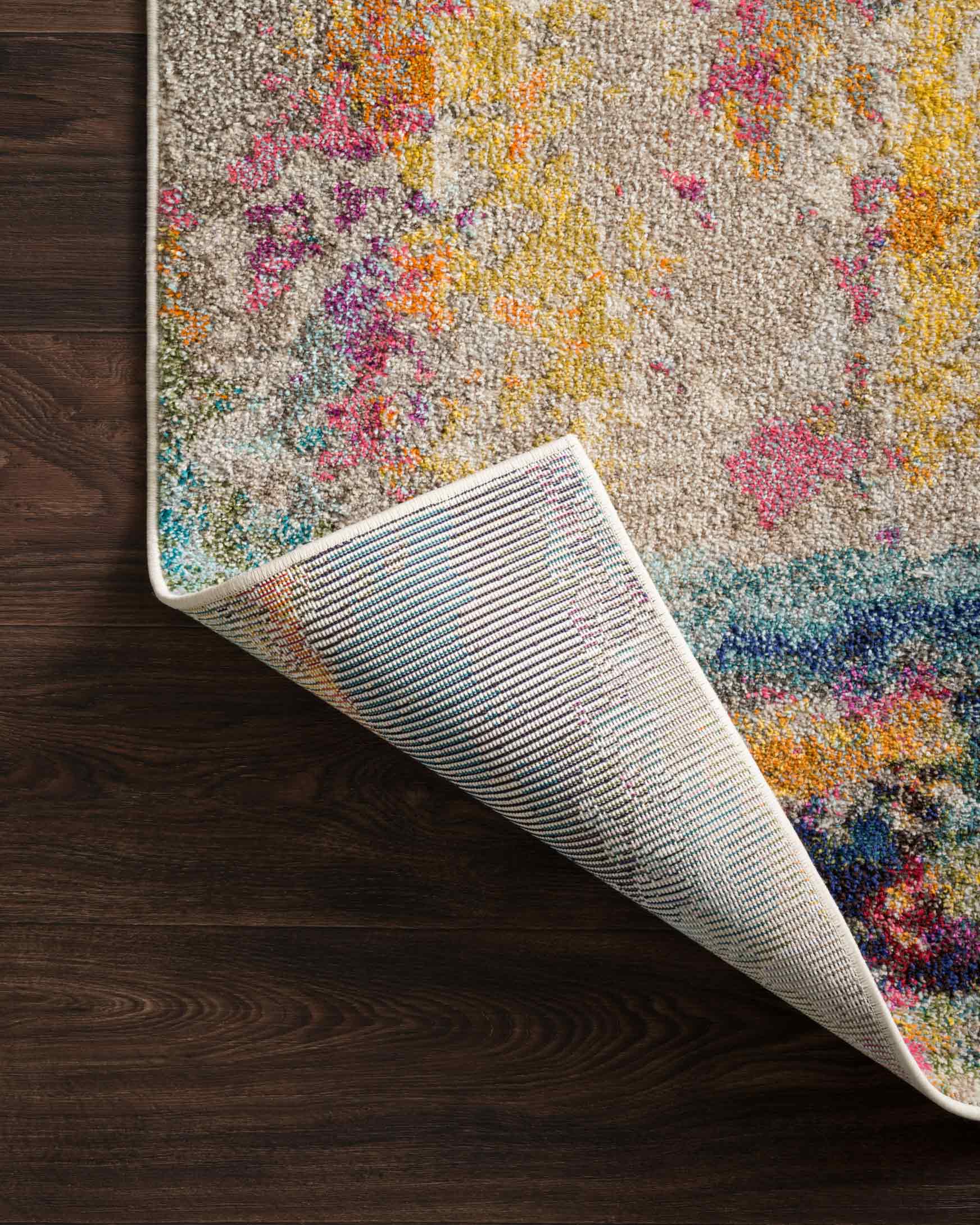 Multicolor abstract rug with bound edge, rolled up to show underside