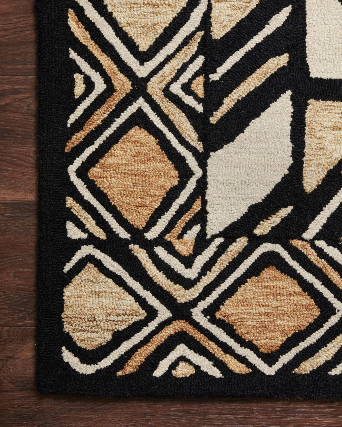 Hand-tufted rug with black background, beige and off-white geometric motifs and diamond blocks.