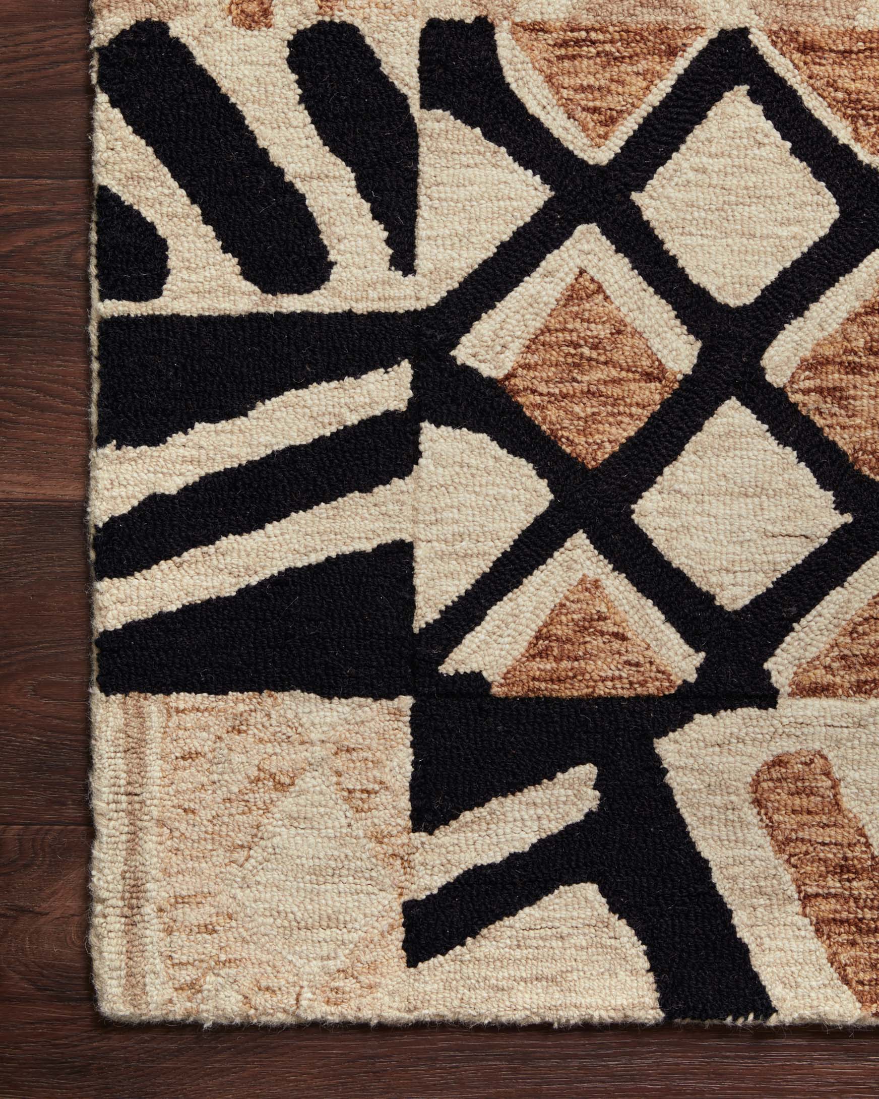Contemporary hand-tufted rug close-up with black, cream, and tobacco geometric motif