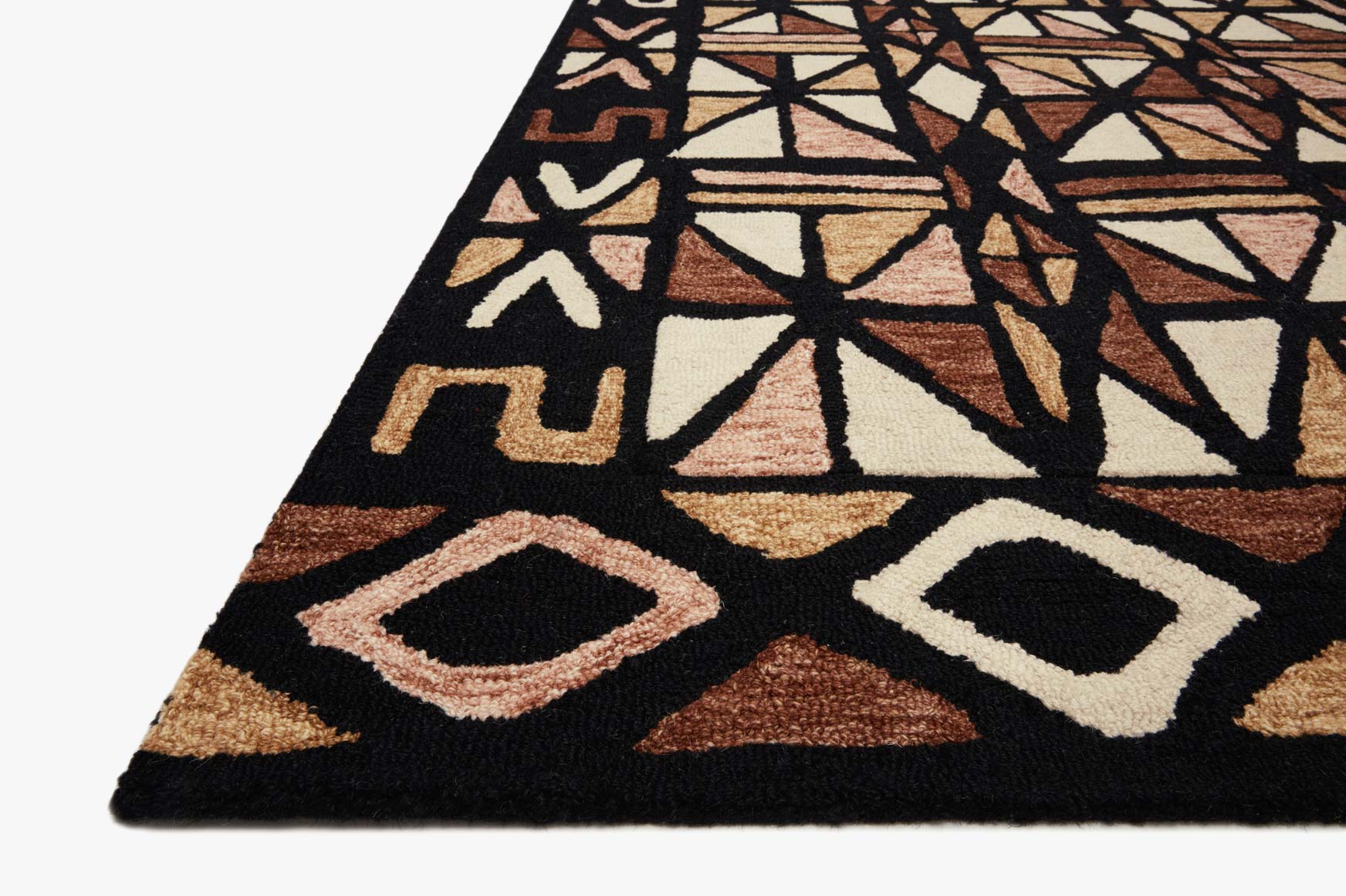 Hand-tufted rug corner with geometric pattern in black, cream, and spice brown and flat border.