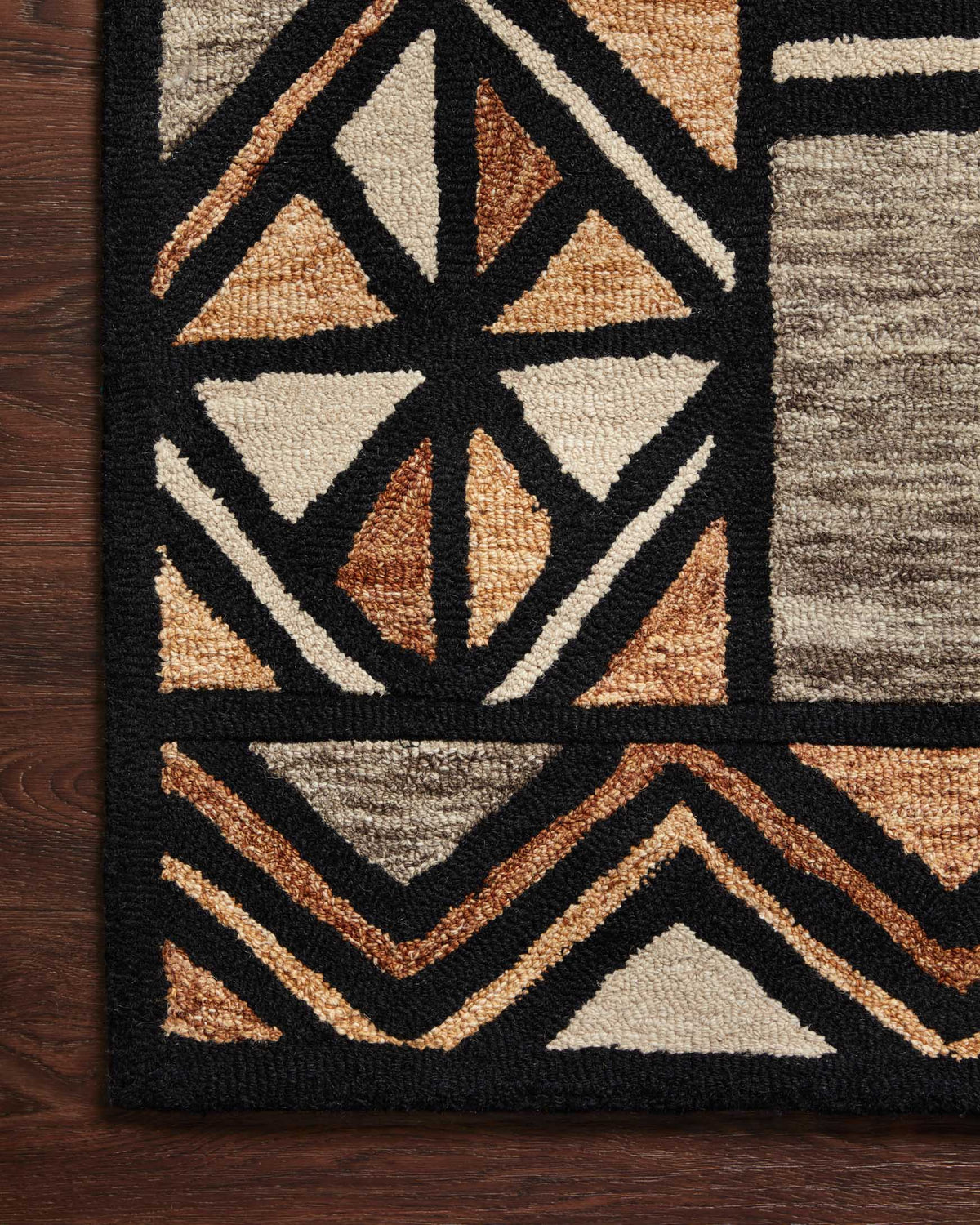 Hand-tufted rug close-up with diamond motifs, zigzag lines, and tan, brown, and black