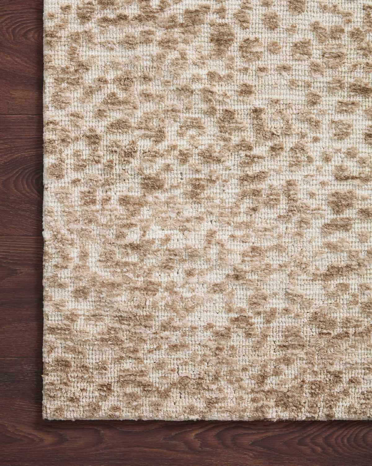 Ivory and sand rug with textured speckled pattern, close-up fabric detail