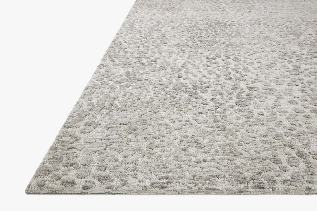 Silver and ivory rug corner showing short, tightly woven speckled pattern and clean edge.