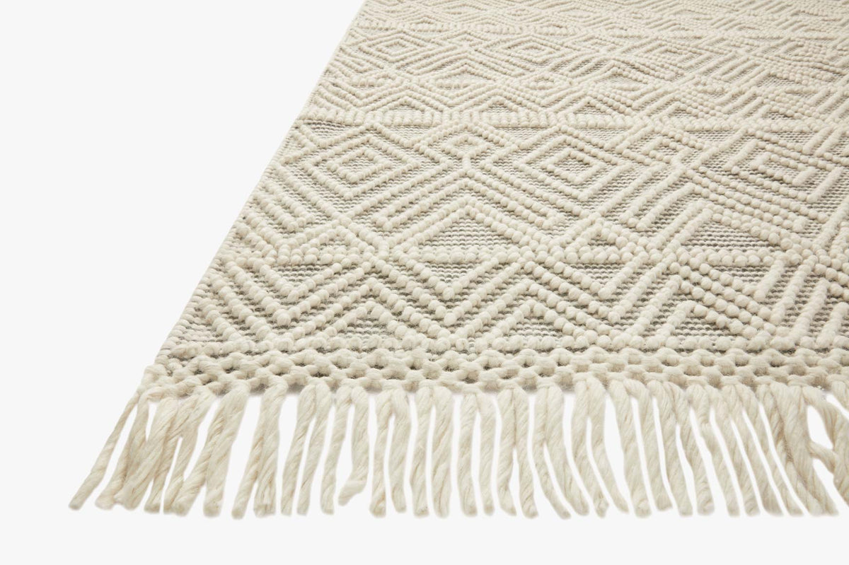 Ivory hand-woven rug with raised diamond pattern and long white tassel fringe