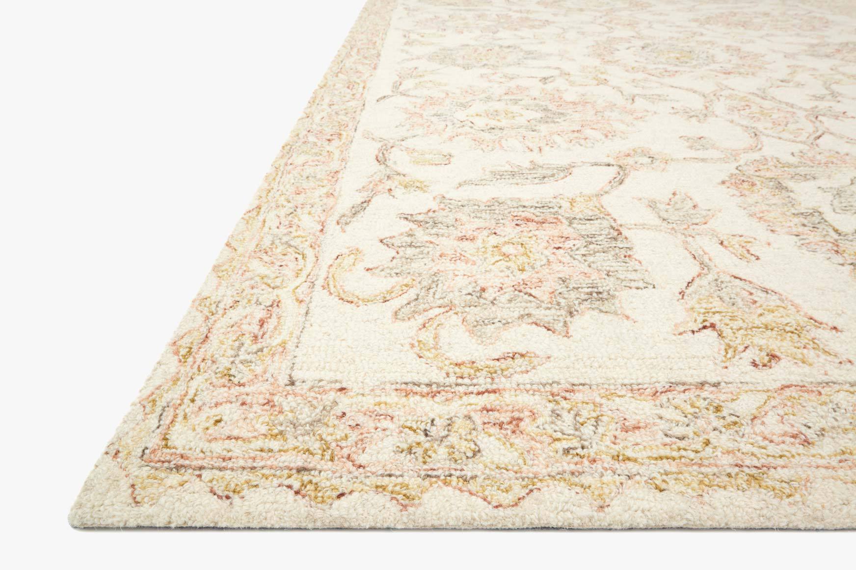 Ivory and blush hooked rug, angled corner view with detailed scrolling pattern
