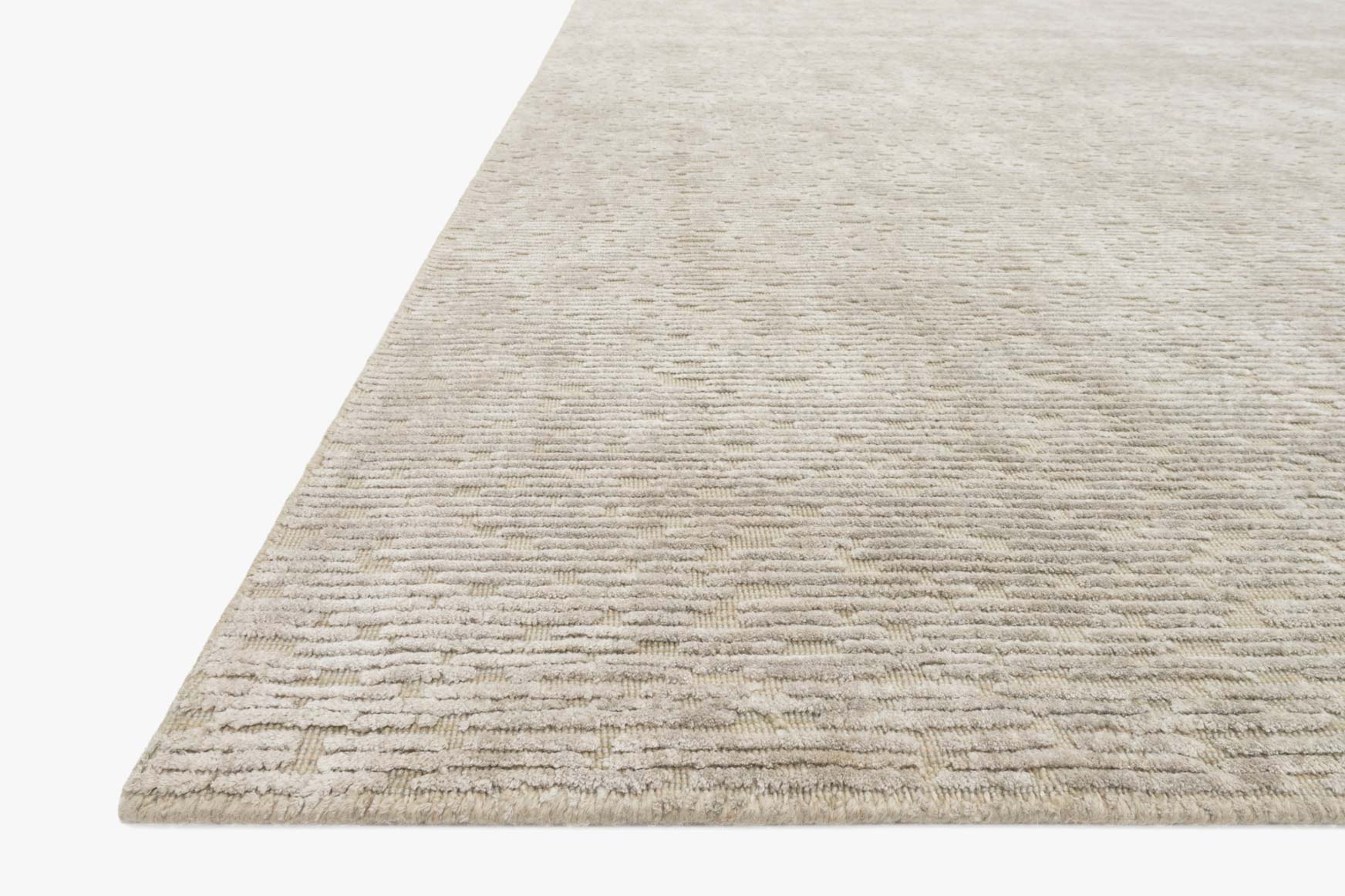 Beige hand-loomed rug corner with low-pile striped texture