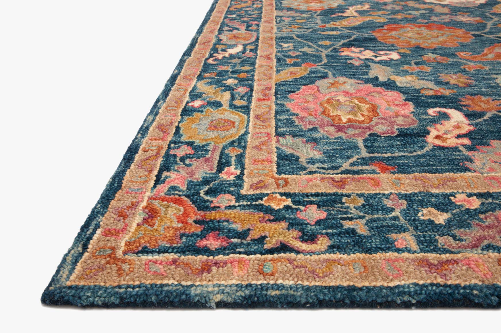 Corner view of transitional hooked rug with blue ground, orange trim, floral motifs.