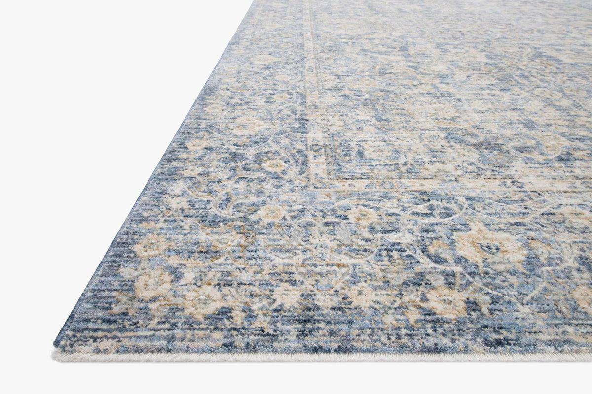 Traditional power-loomed rug corner in light blue with gold abstract border detail