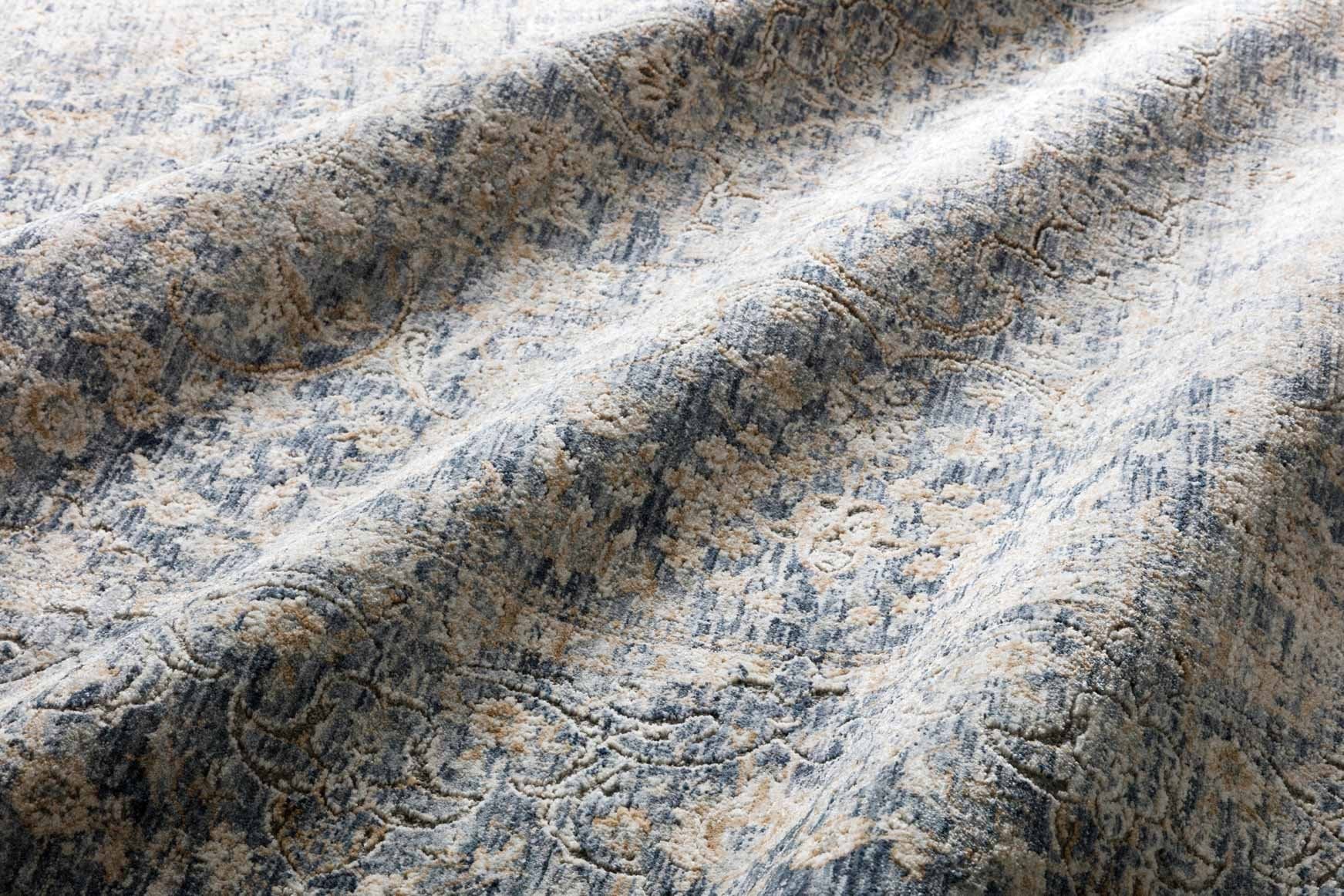 Close-up of traditional power-loomed rug texture in blue with gold-toned accents