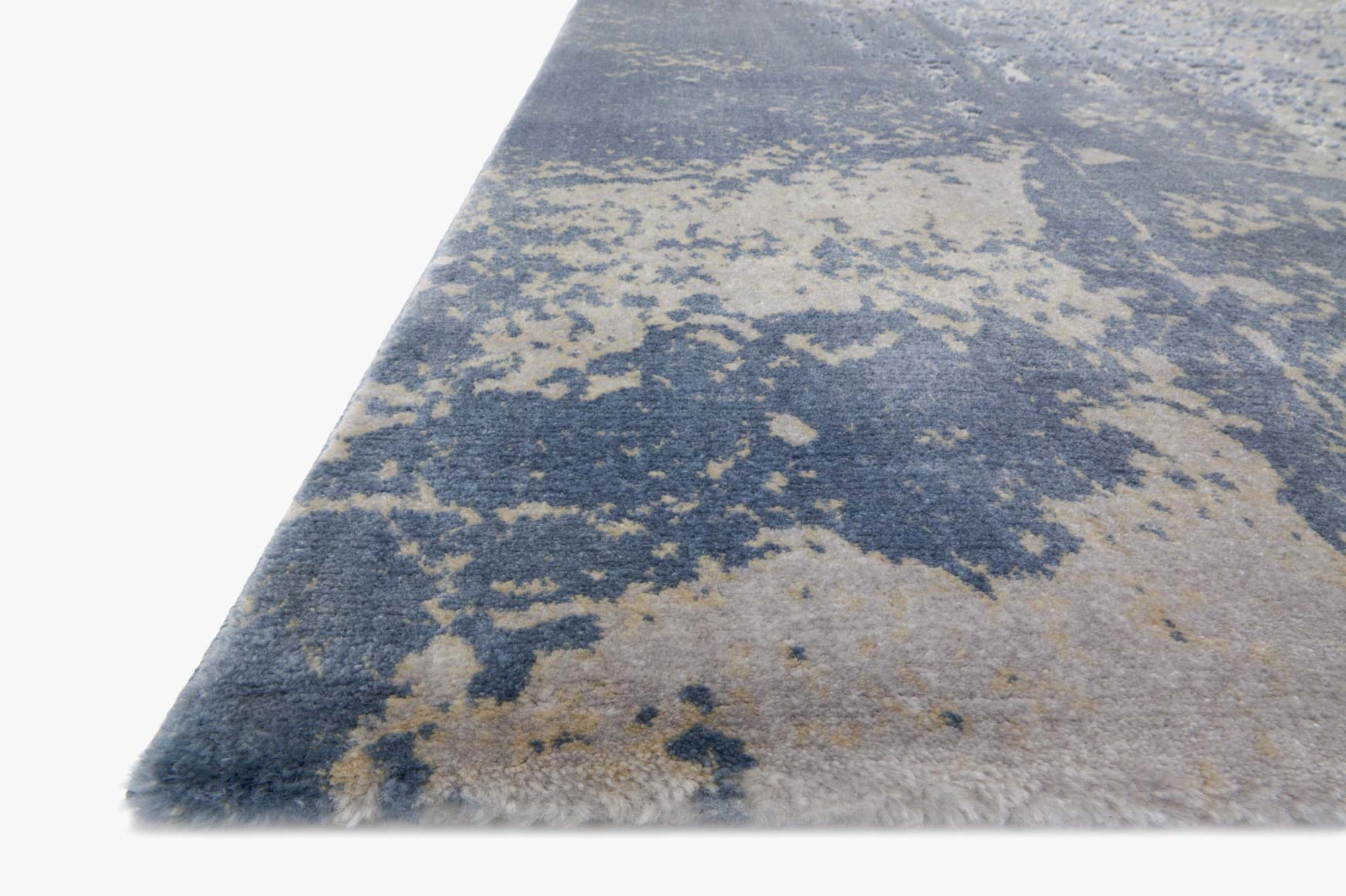 Transitional power-loomed rug in denim and grey with distressed abstract pattern, angled view