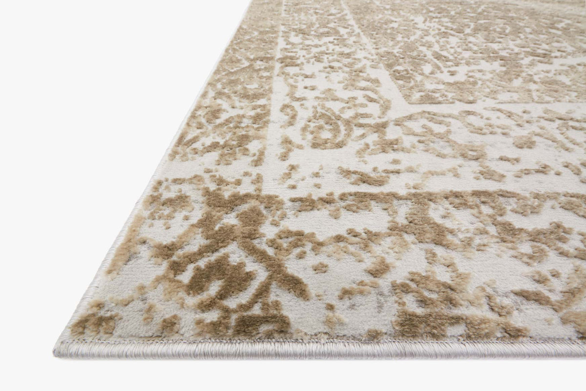 Corner close-up of power-loomed rug in champagne and light gray with distressed motif