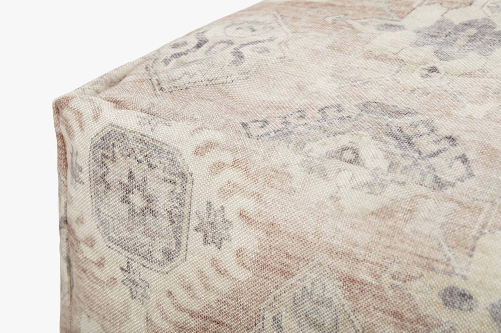 Beige patterned fabric pouf with corner seam and textured weave detail