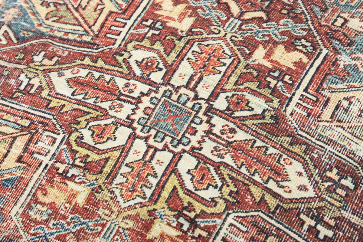 Close-up of geometric woven pouf fabric in rust, cream, and teal tones