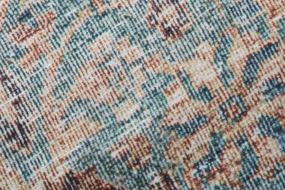 Woven fabric close-up on geometric-pattern pouf in blue, tan, and rust orange.