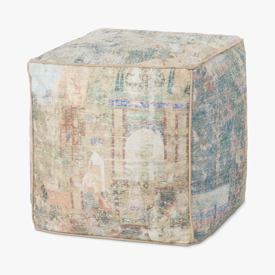 Square pouf ottoman in blue-and-cream patchwork with multicolor abstract motif.