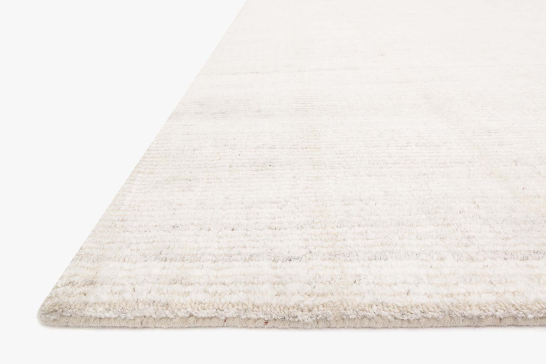 Ivory transitional hand loomed rug corner with textured pile and subtle woven stripes