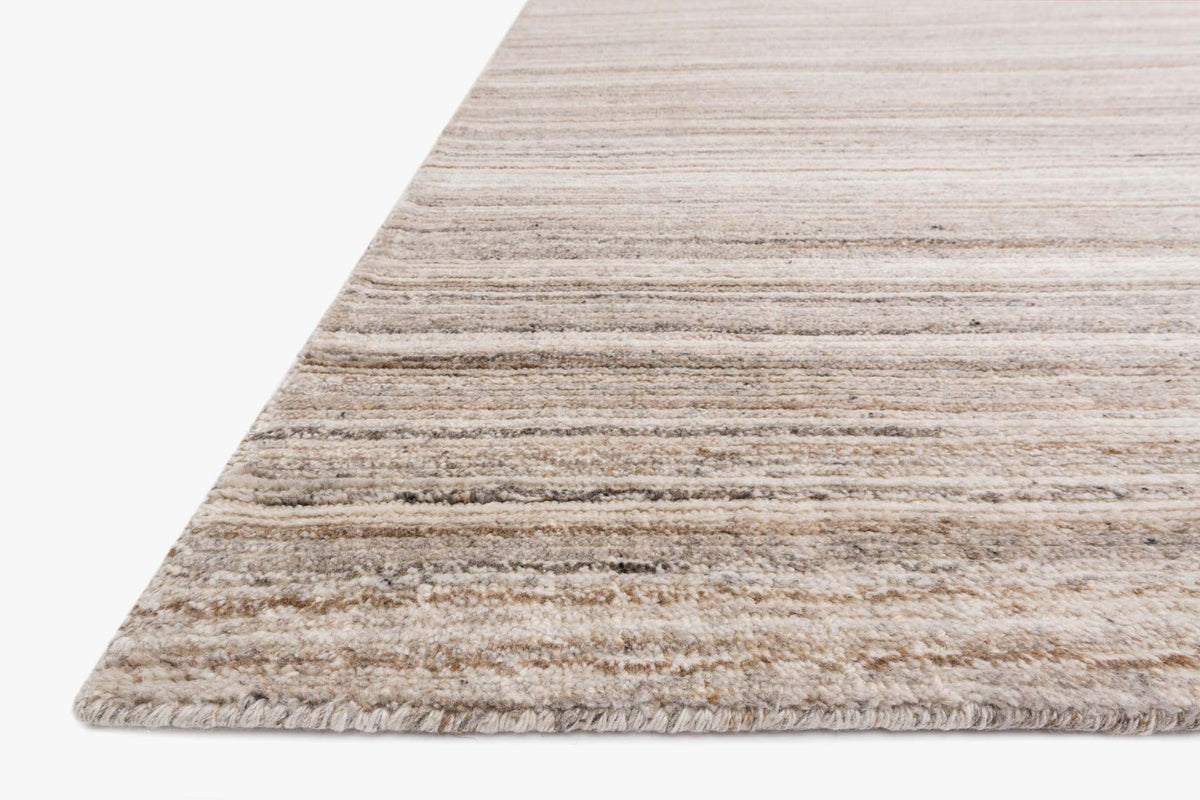 Transitional hand-loomed rug corner with low pile and woven horizontal stripe texture, mocha