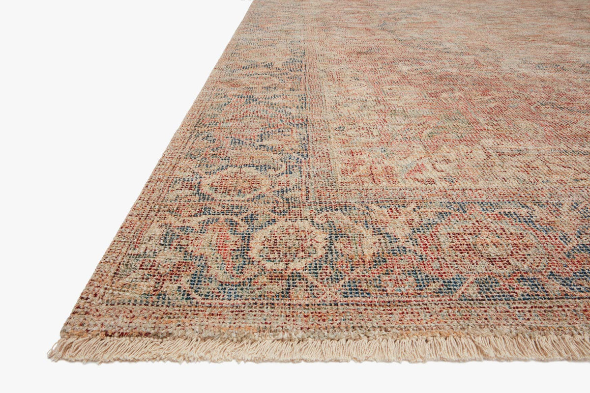 Hand-woven rug corner in brick, navy and beige with short fringe edging