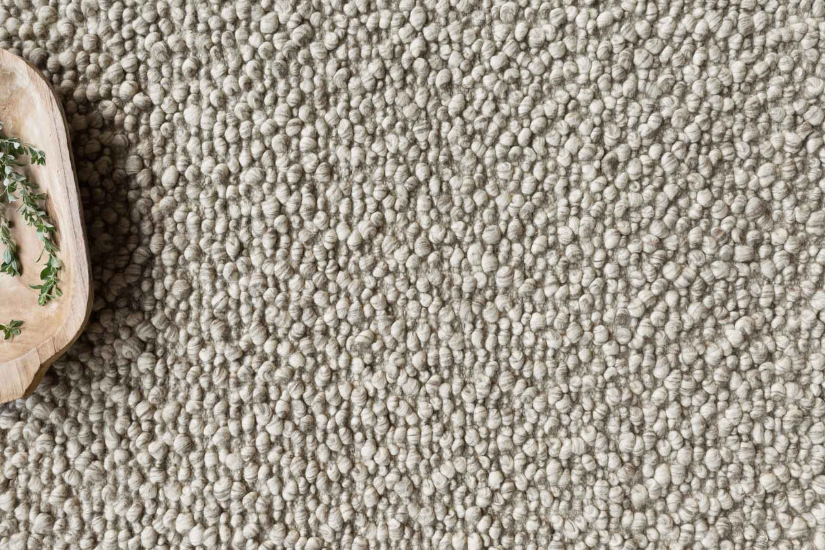 Stone rug close-up showing dense looped yarn texture