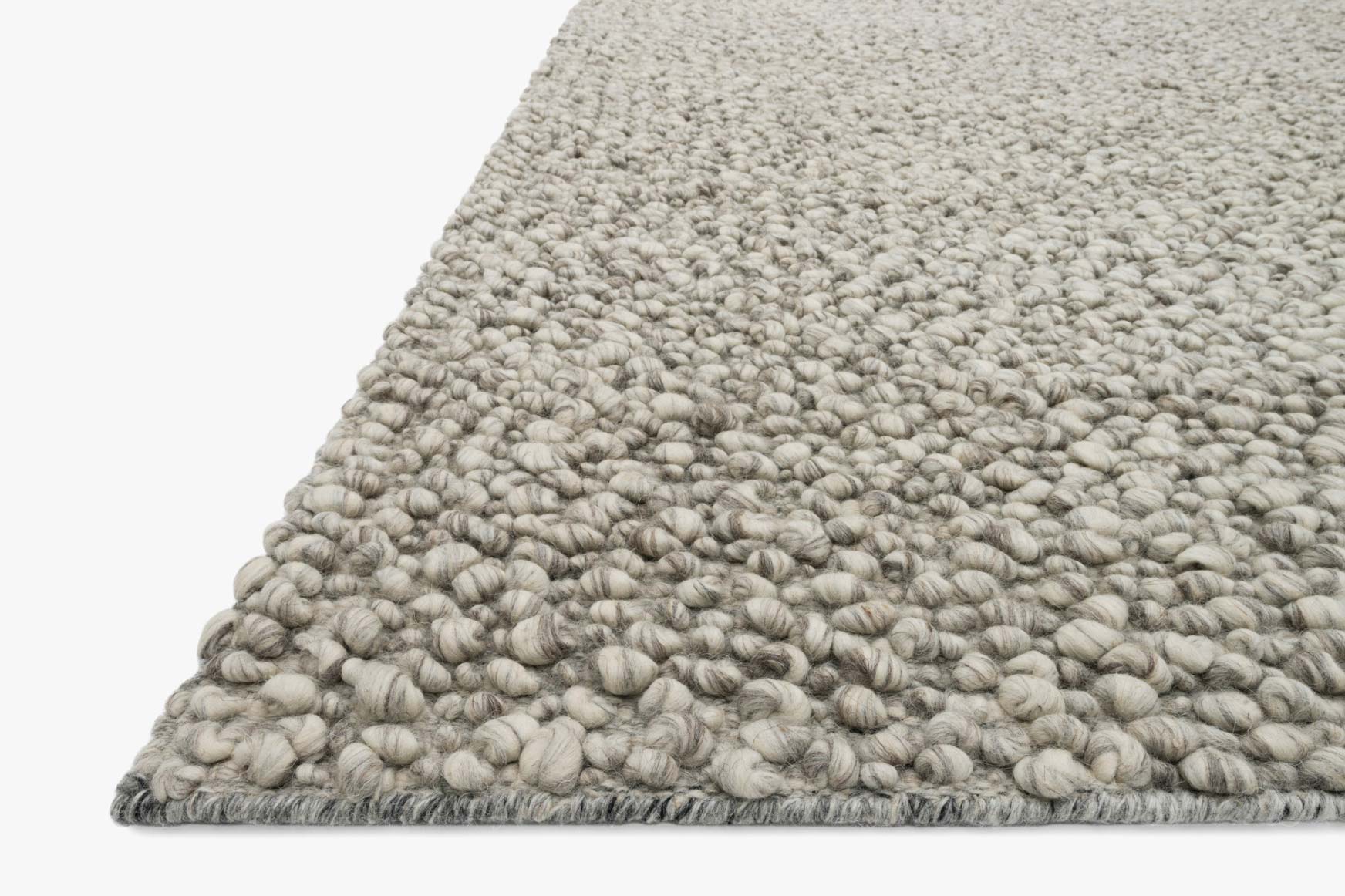 Stone hand-woven rug corner with textured edge and dense loop pile