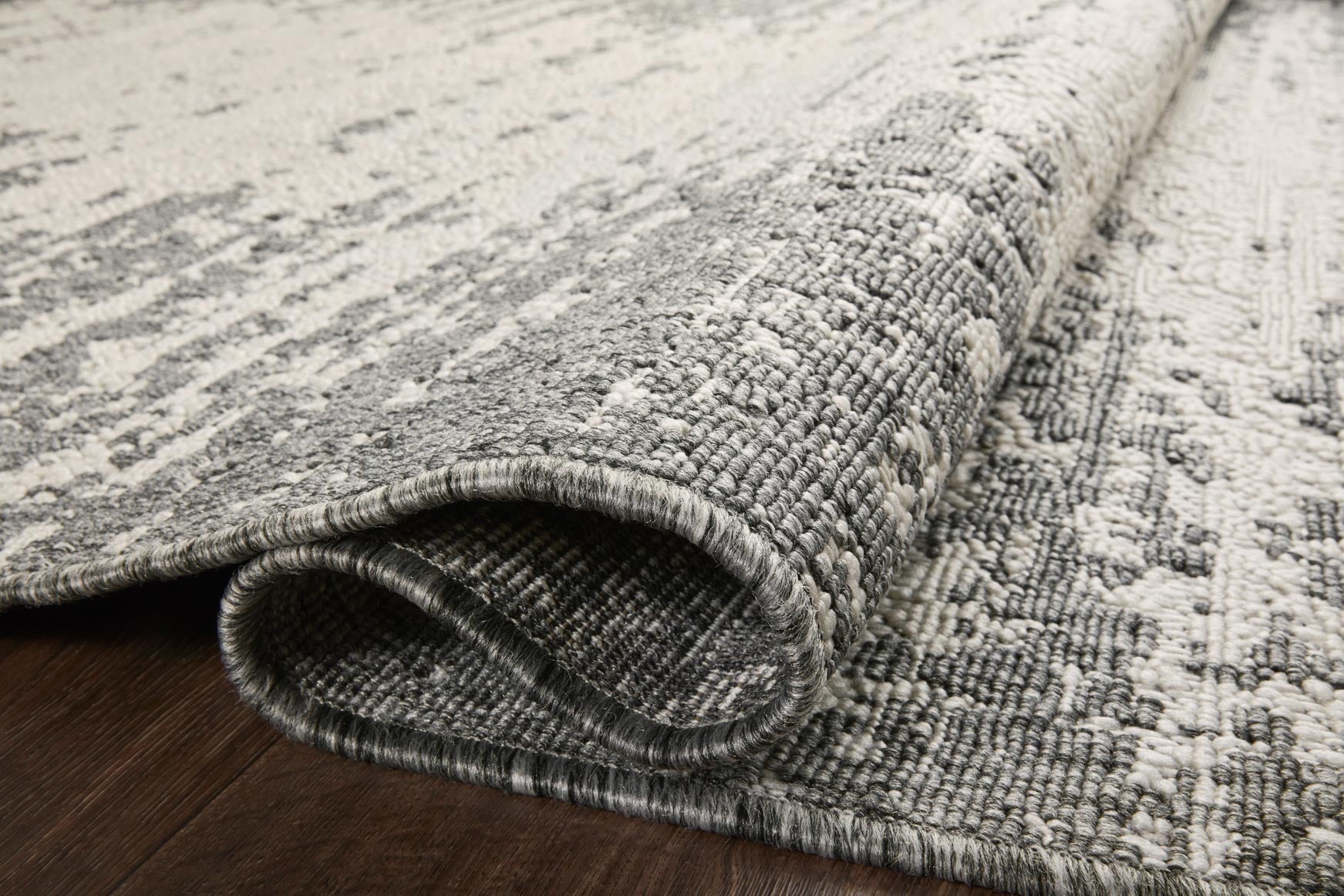 Close-up of ivory and grey rug pile texture and bound edge