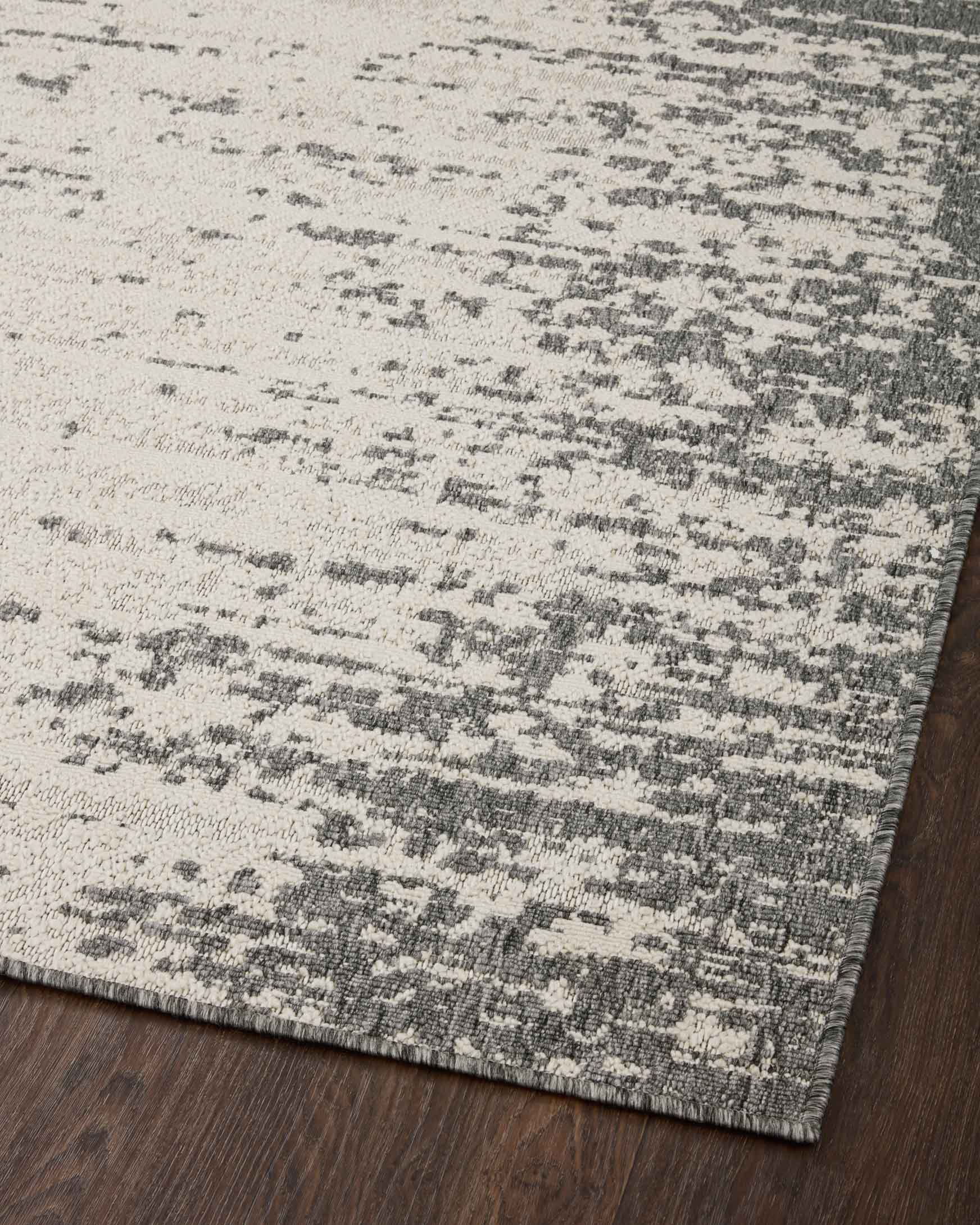 Ivory and grey power-loomed rug with abstract pattern on dark wood floor