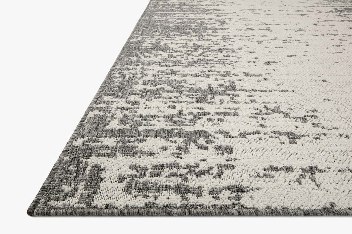 Corner close-up of ivory and grey power-loomed rug with abstract pattern