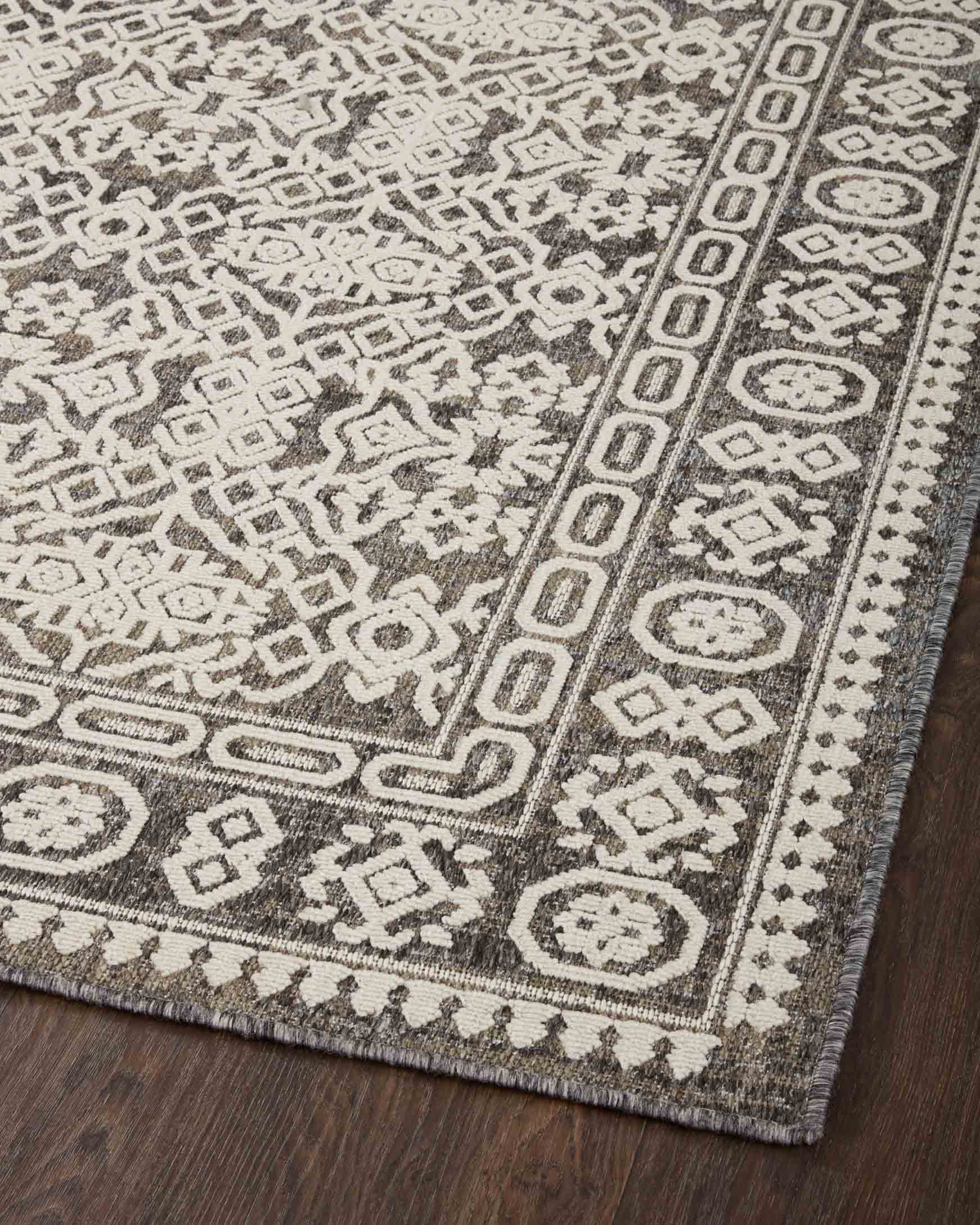 Top view of pebble gray and ivory rug with dense geometric motifs and striped border