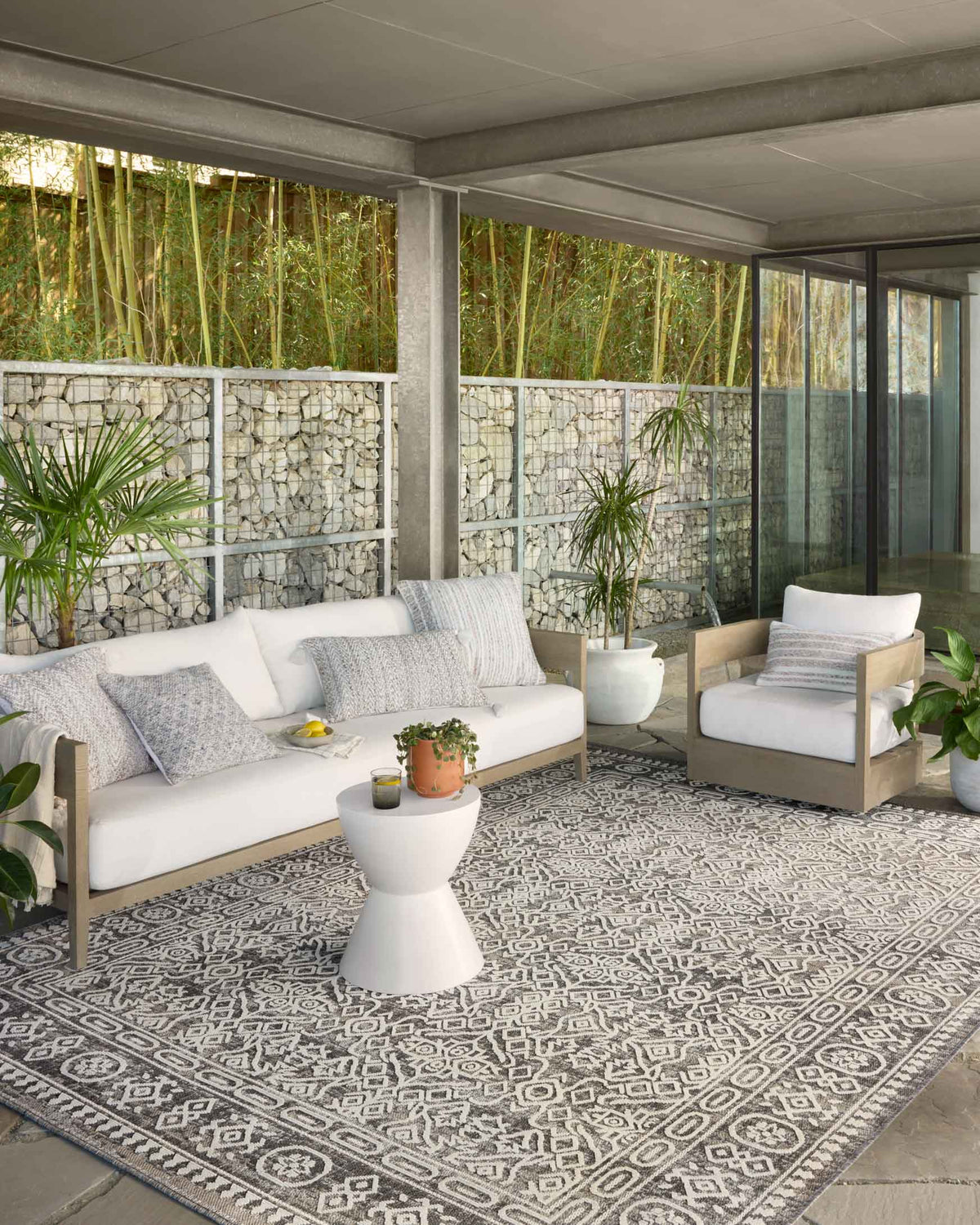 Indoor/outdoor geometric area rug in pebble gray and ivory under outdoor seating