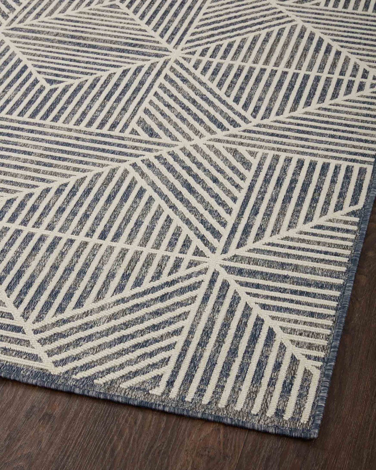 Denim and ivory geometric rug close-up with repeating fan and stripe motifs