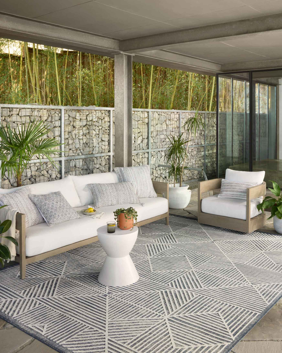 Denim and ivory geometric indoor/outdoor rug laid on an outdoor patio floor