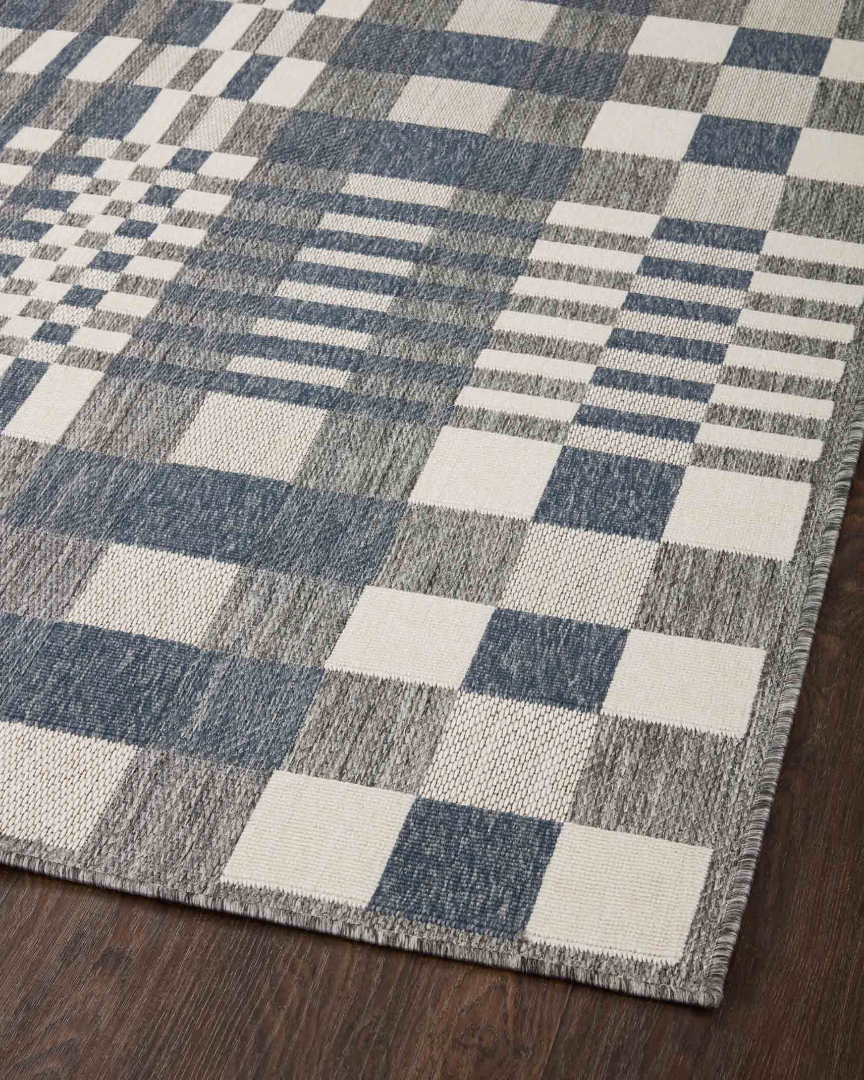 Indoor/outdoor power-loomed rug with checker and stripe pattern in ivory and denim.
