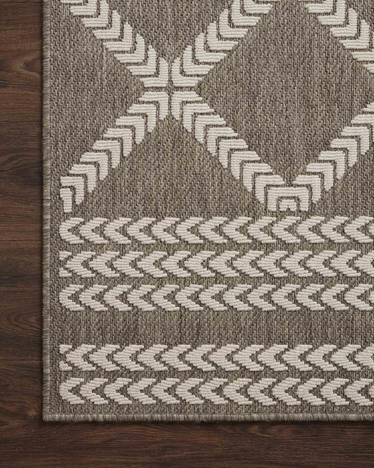 Indoor/outdoor rug detailed pattern with dark gray blocks and ivory geometric rows