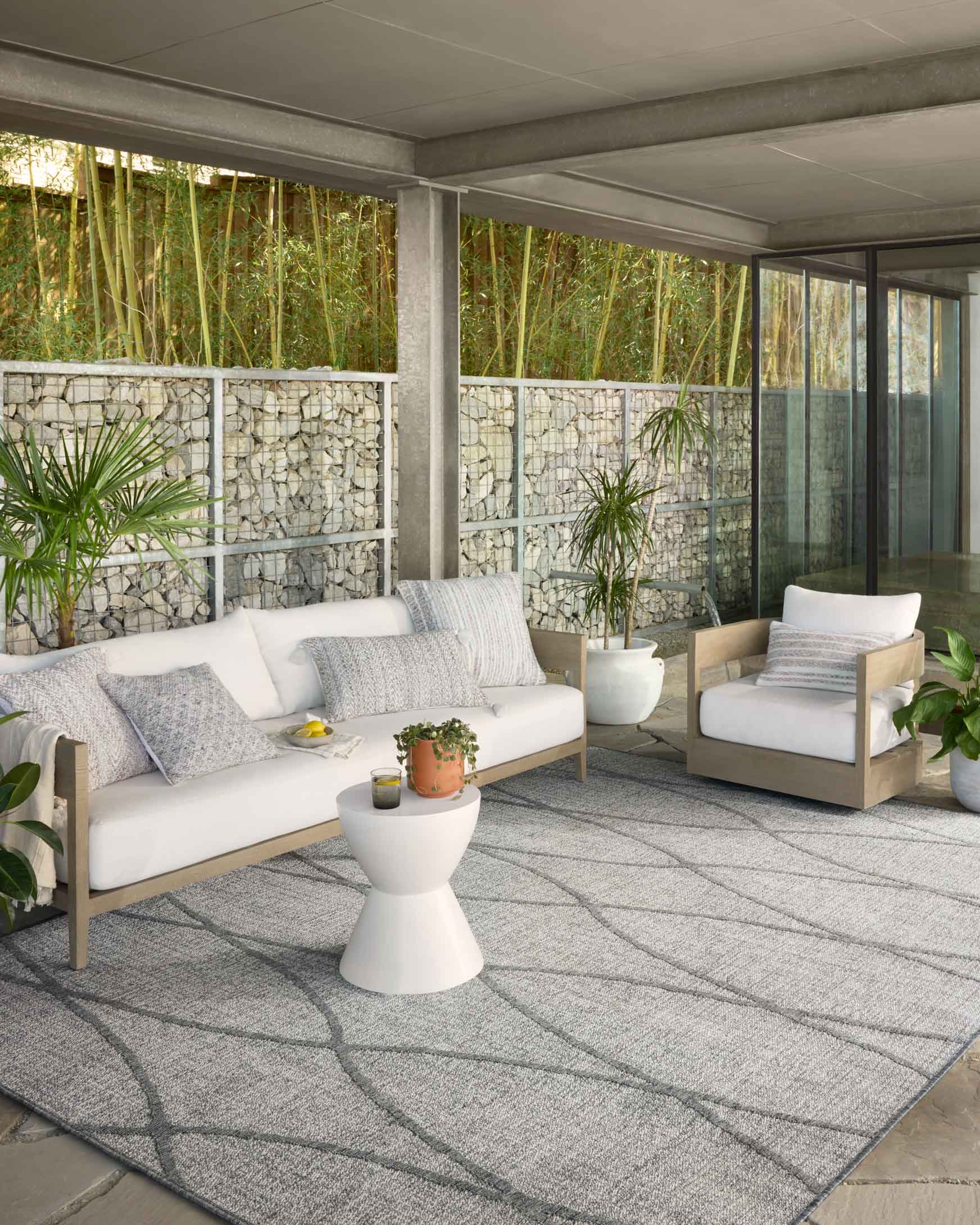 Light grey indoor/outdoor rug with dark grey lattice pattern on outdoor floor