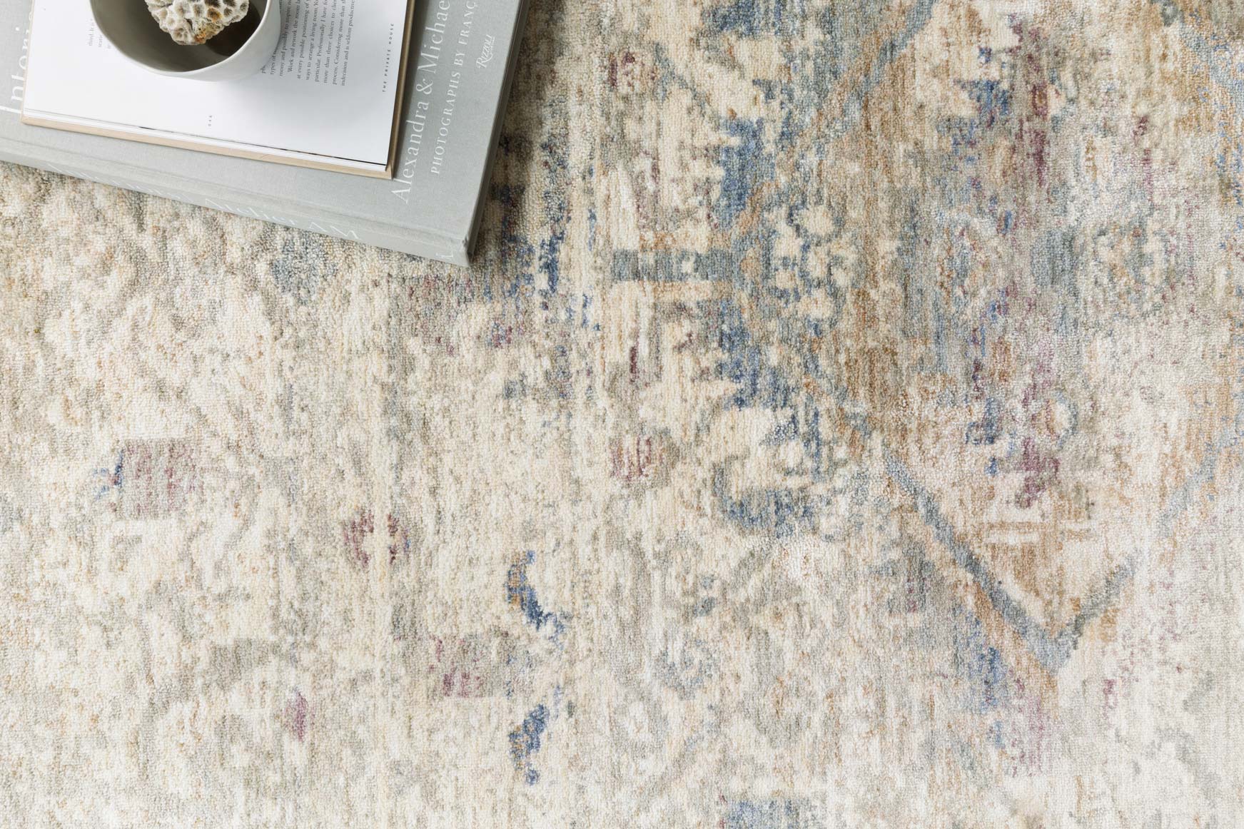 Traditional power loomed rug close-up: ivory and blue distressed motif and texture