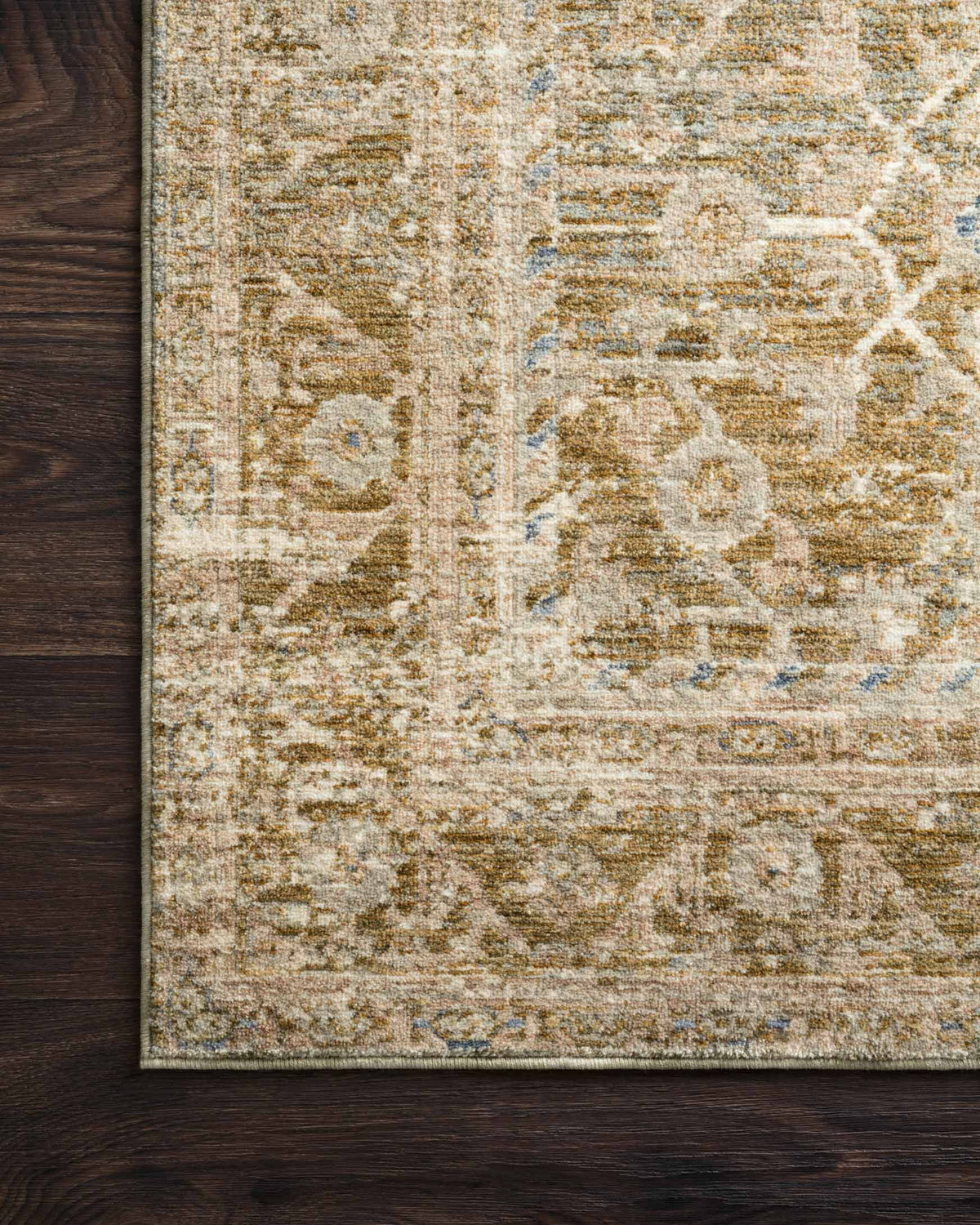 Traditional power-loomed rug close-up with textured weave, ornate motifs in beige and olive.
