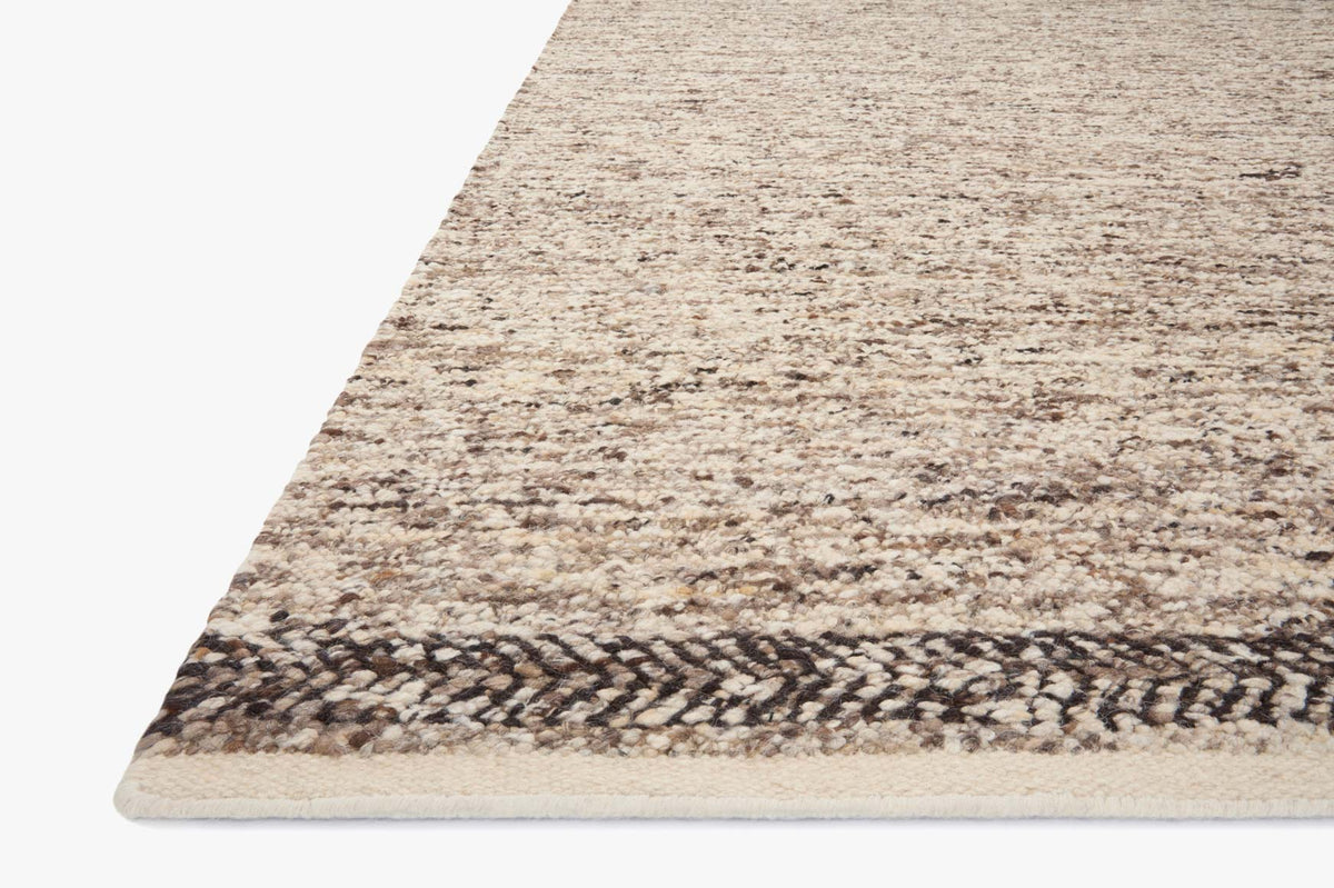 Corner of granite and mocha hand-woven rug with flat weave border